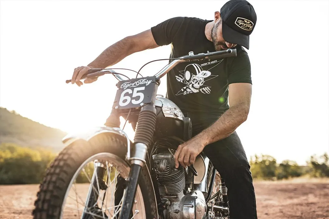 Photo of a man wearing Age of Glory clothing whilst sitting on desert sled / scrambler type bike
