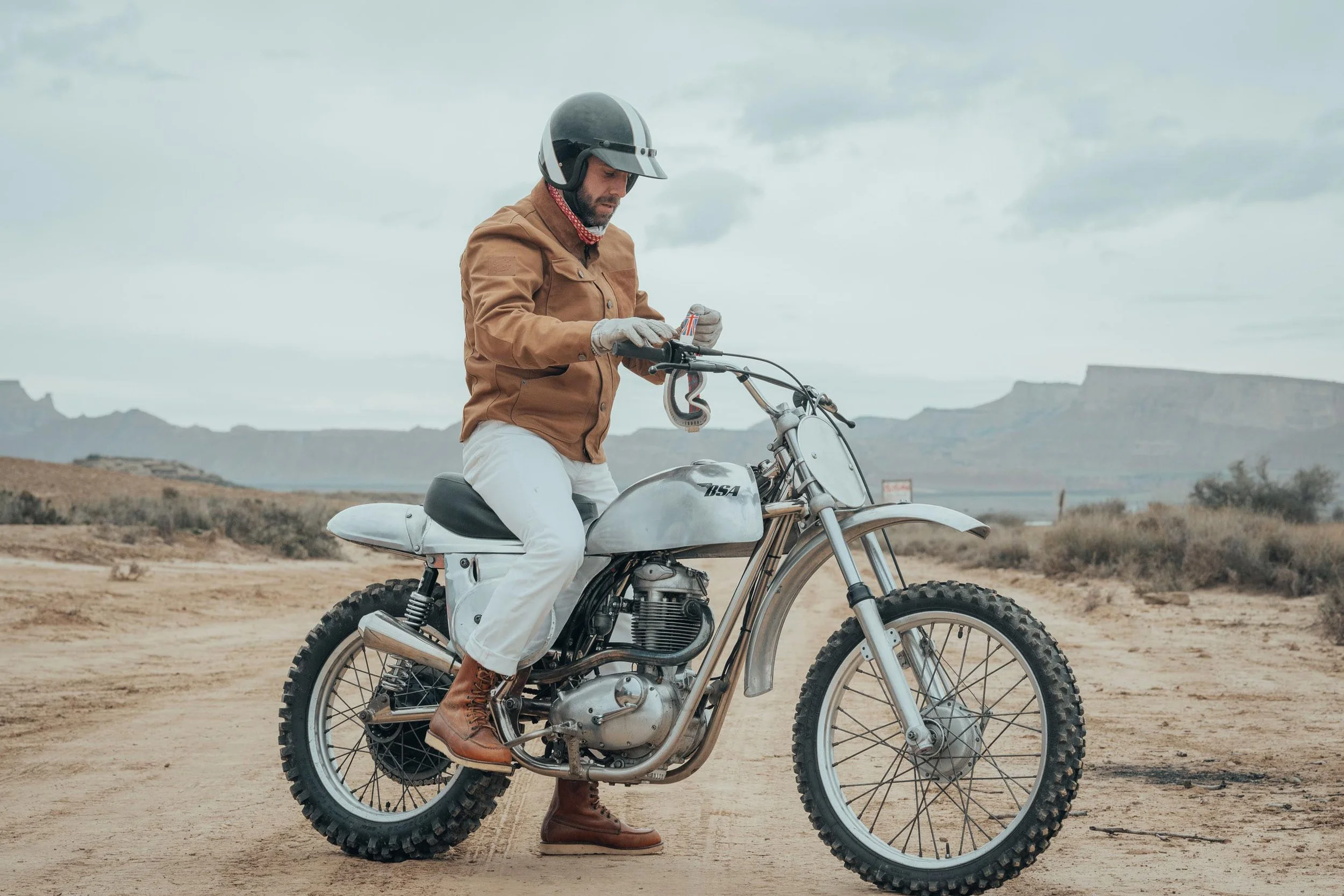 Photo of a man wearing Age of Glory clothing whilst sitting on desert sled / scrambler type bike