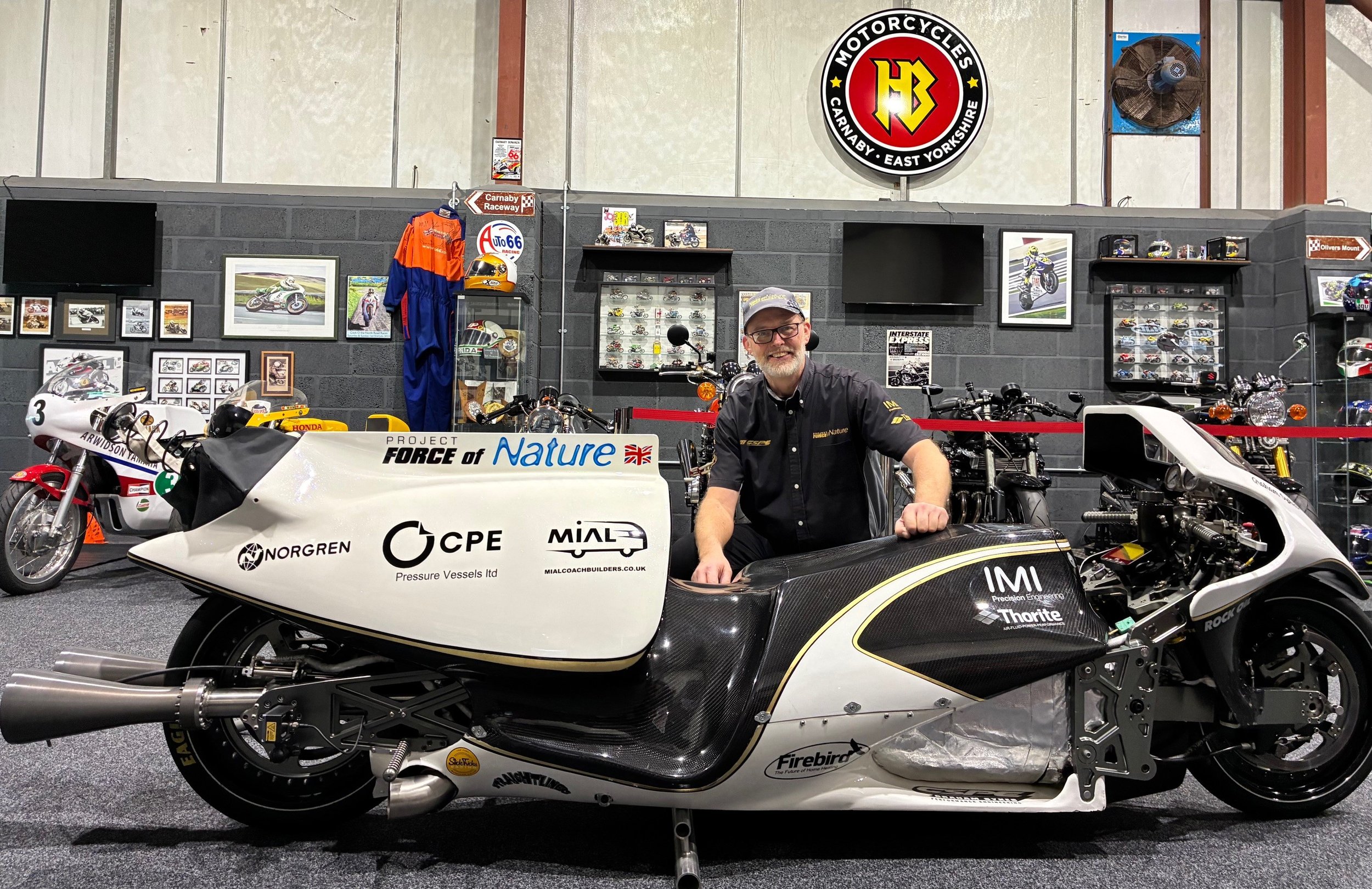 Photo of Graham Sykes next to the Force of Nature steam rocket bike