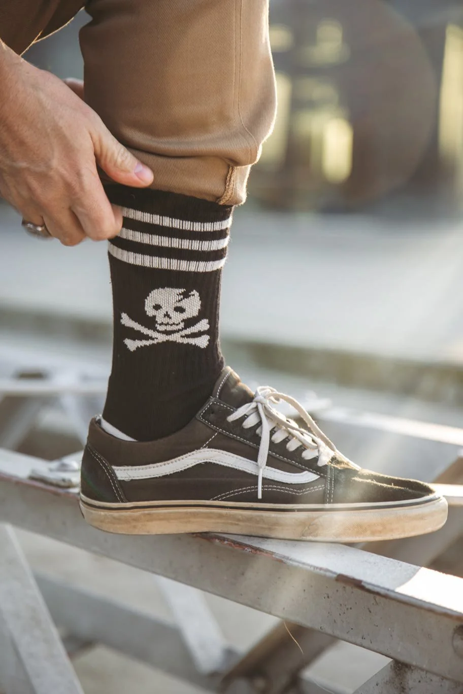 Close-up photo of a man wearing Age of Glory socks with a skull and crossbones motif