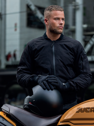 Photo of a man wearing a black Oxford bomber jacket