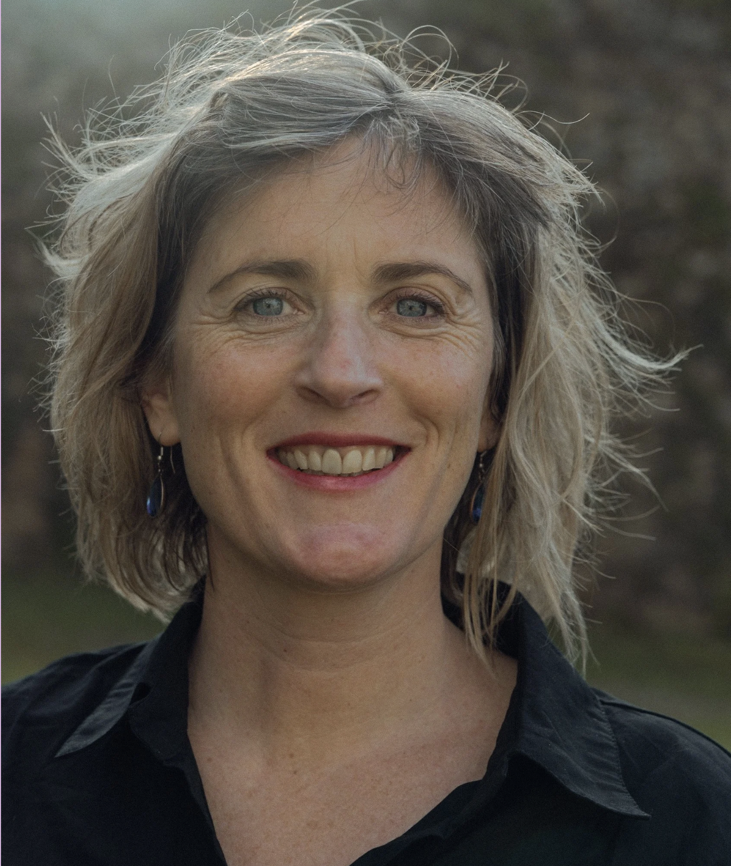 Karen Egan — somatic sexologist, headshot smiling outdoors with natural green background — review of Catherine Hale's coaching.