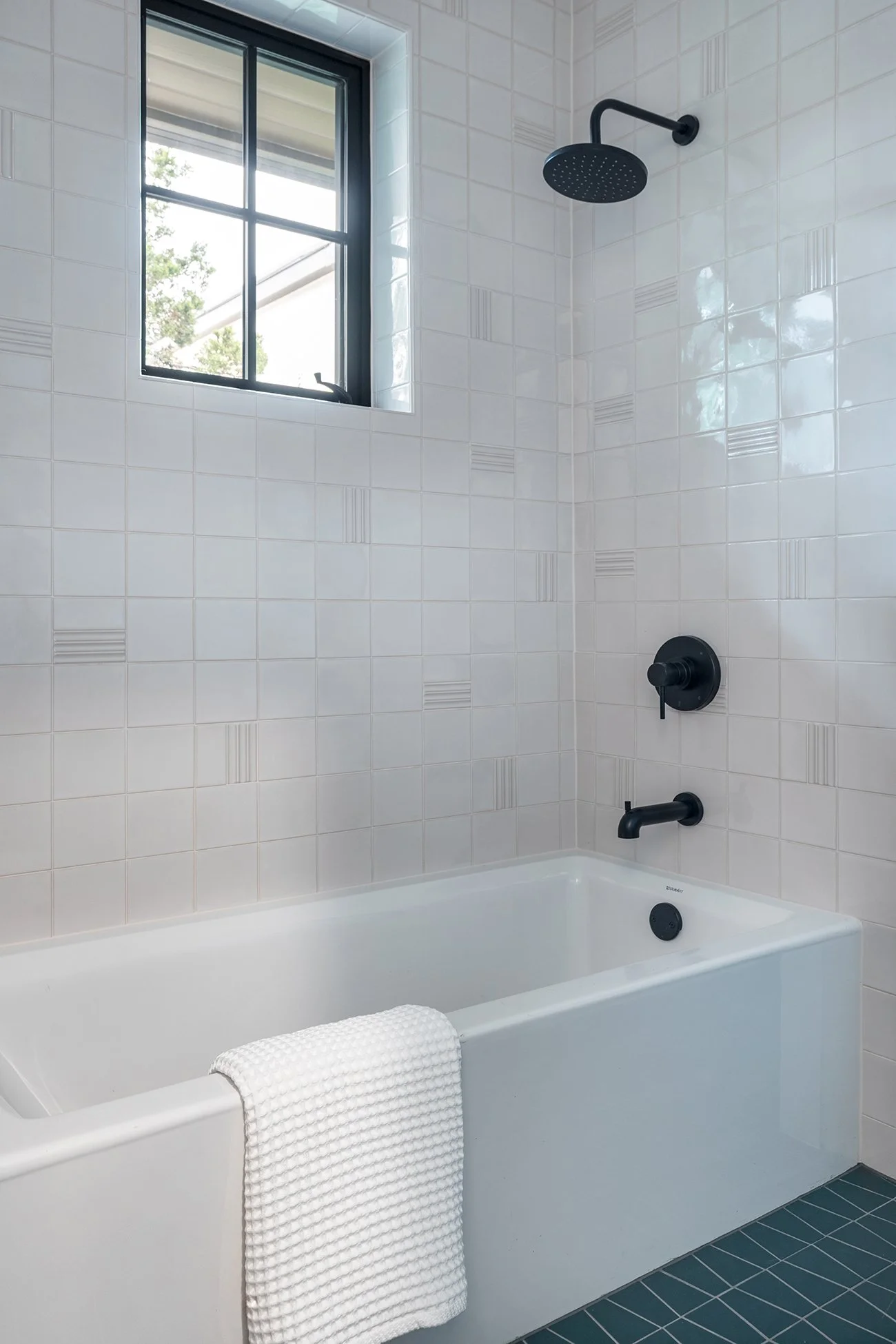 Modern tub and shower with clean-lined textural tile and warm contemporary finishes in a Northwest Hills Austin home by Christen Ales Interiors.