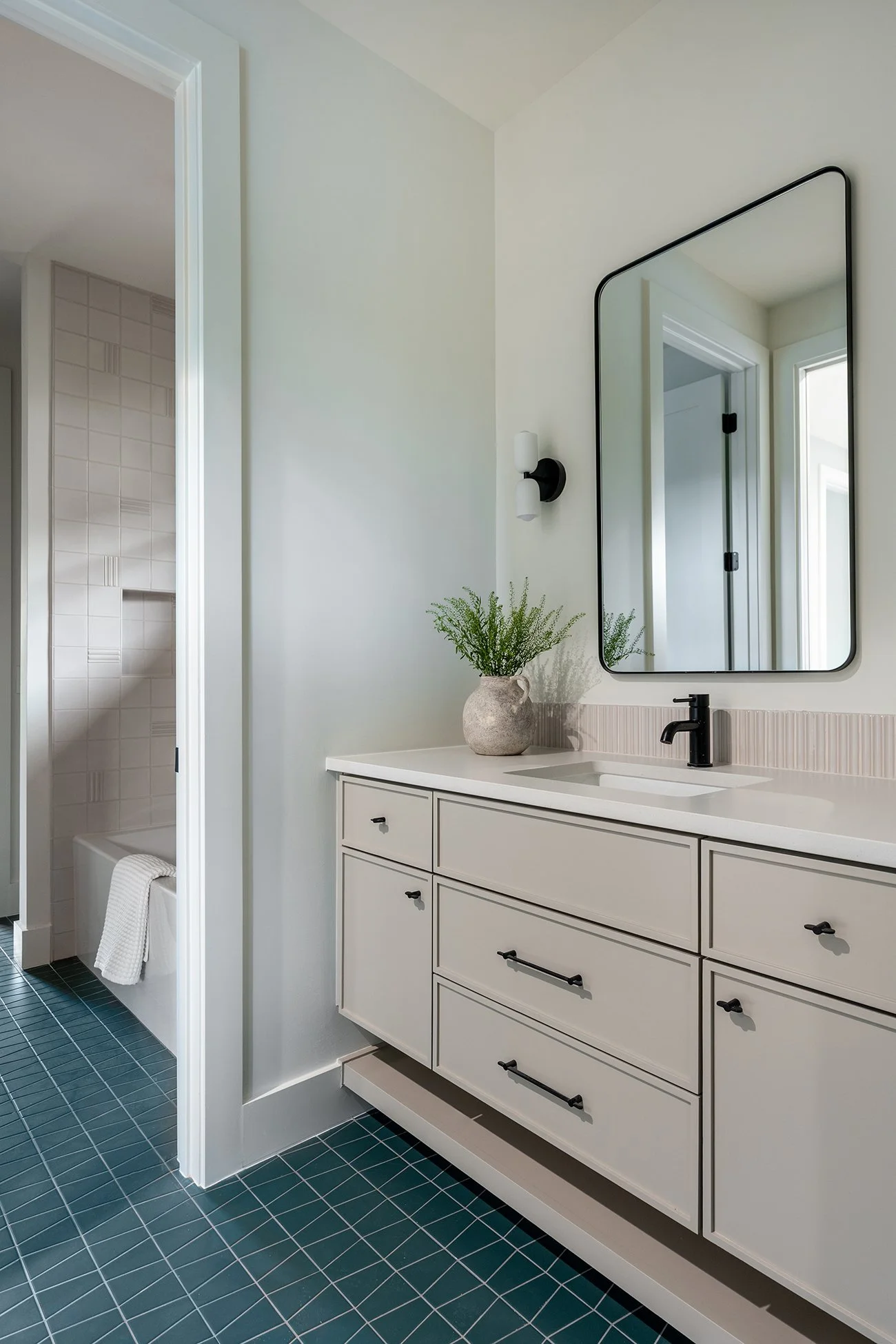 Modern bathroom with bold geometric floor tile and warm contemporary finishes in a Northwest Hills Austin home by Christen Ales Interiors.