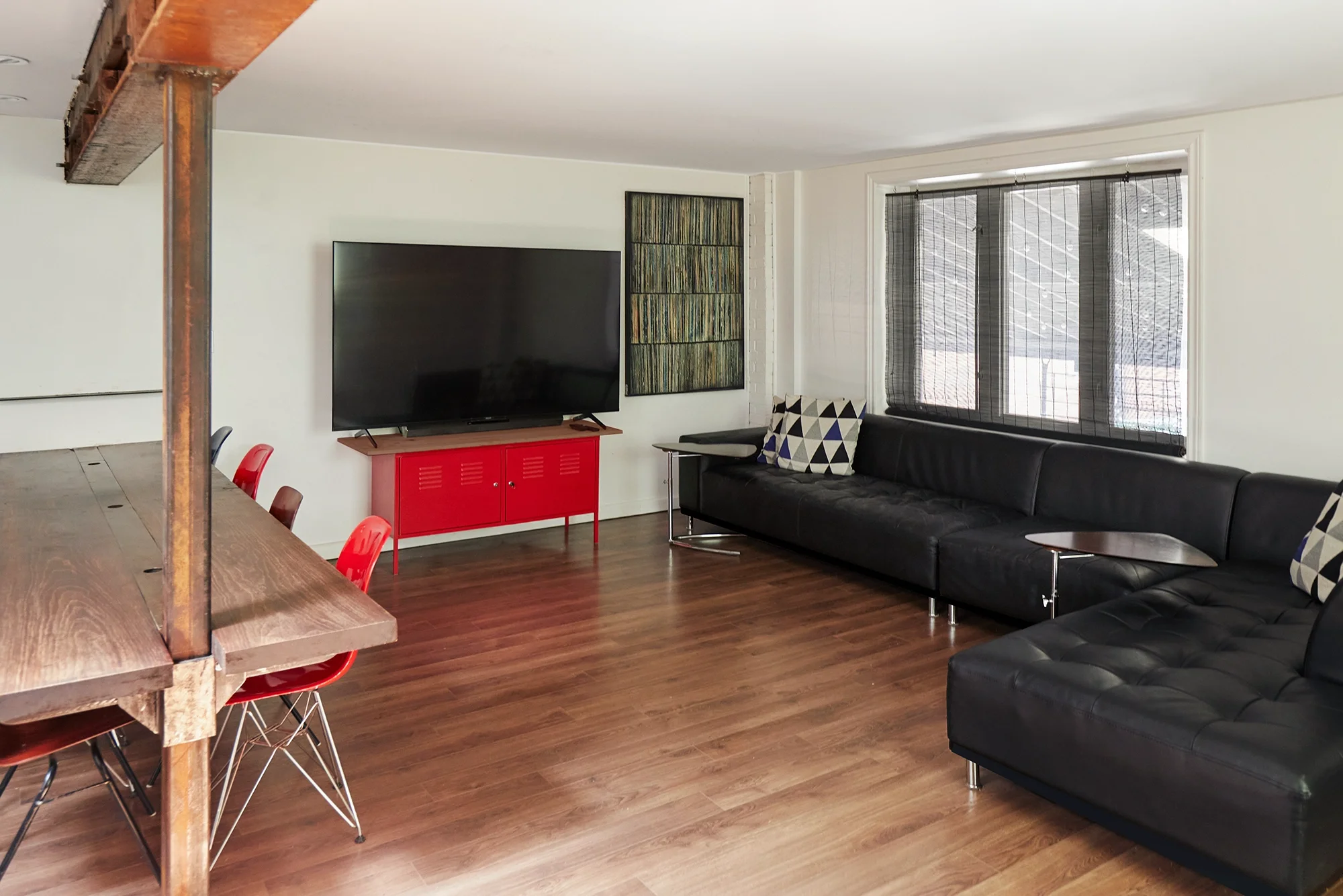 Mezzanine client lounge at Sterling Studio in Toronto with workstations, seating, and a large TV for live camera feed monitoring.