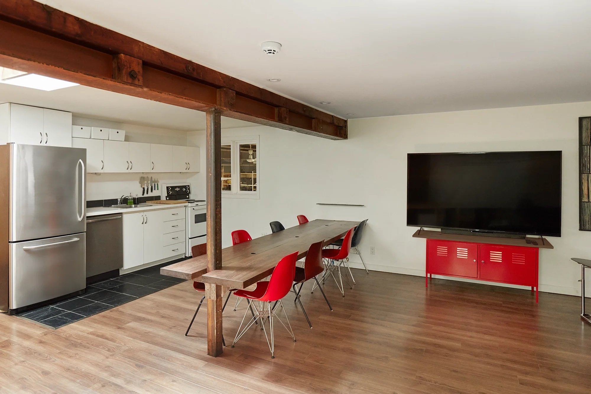 Mezzanine client lounge at Sterling Studio in Toronto with workstations, seating, and a large TV for live camera feed monitoring.