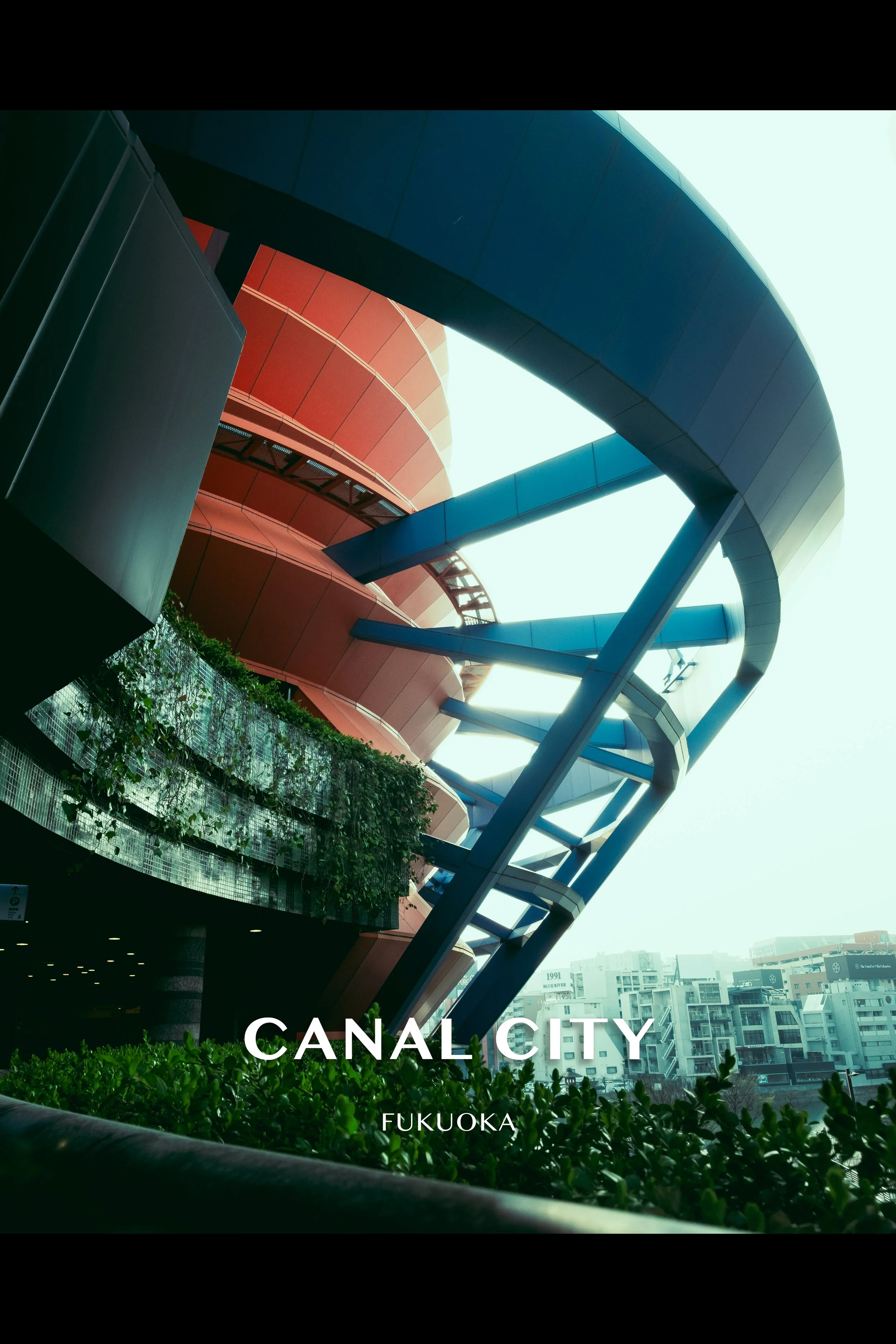 Modern architectural structures featuring a spiraling blue walkway and a red building in Canal City, Fukuoka.