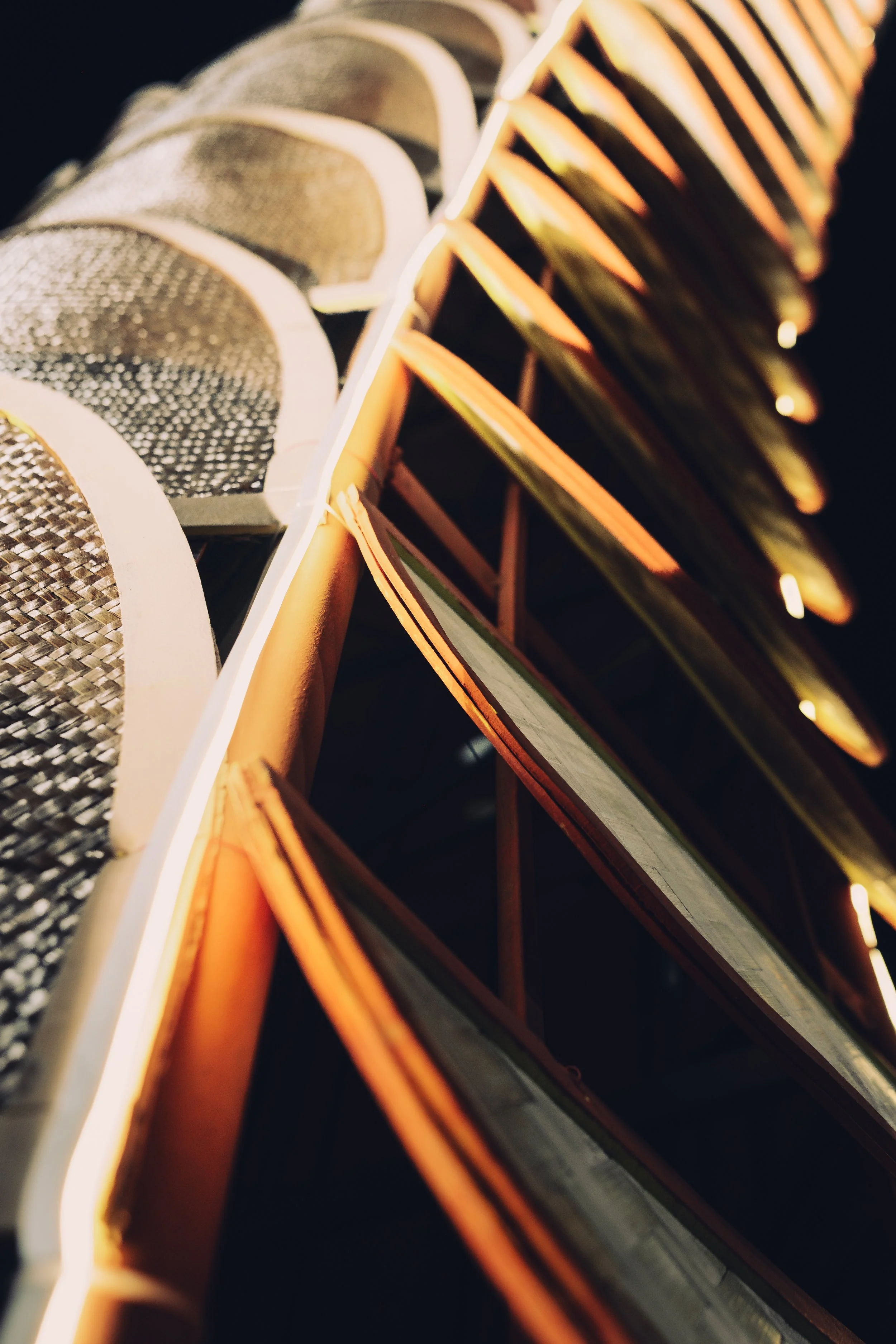 Close-up of illuminated signs with textured surfaces and neon lighting, emphasizing lines and shapes.