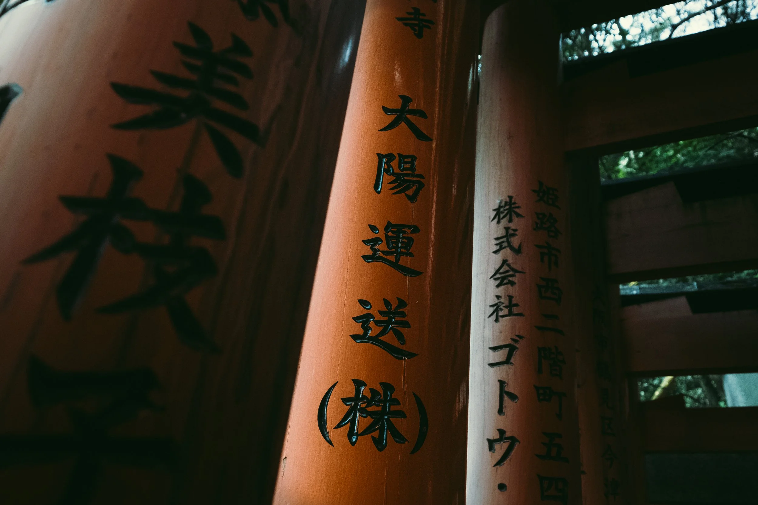 Close-up of Japanese calligraphy inscription on wooden beams of a shrine or temple.