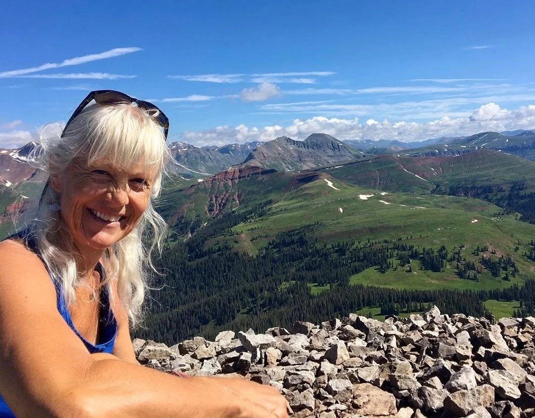 Laurie on top of a peak in the San Juan Mountains.