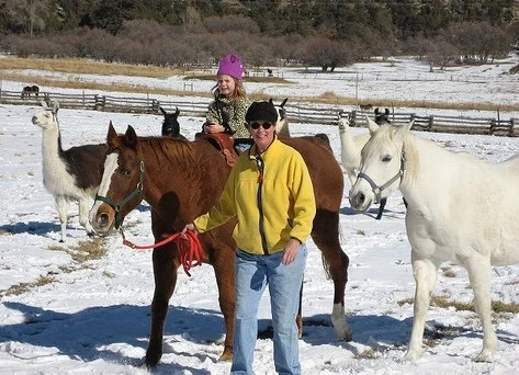 Leading a horse with a thrilled little girl astride.