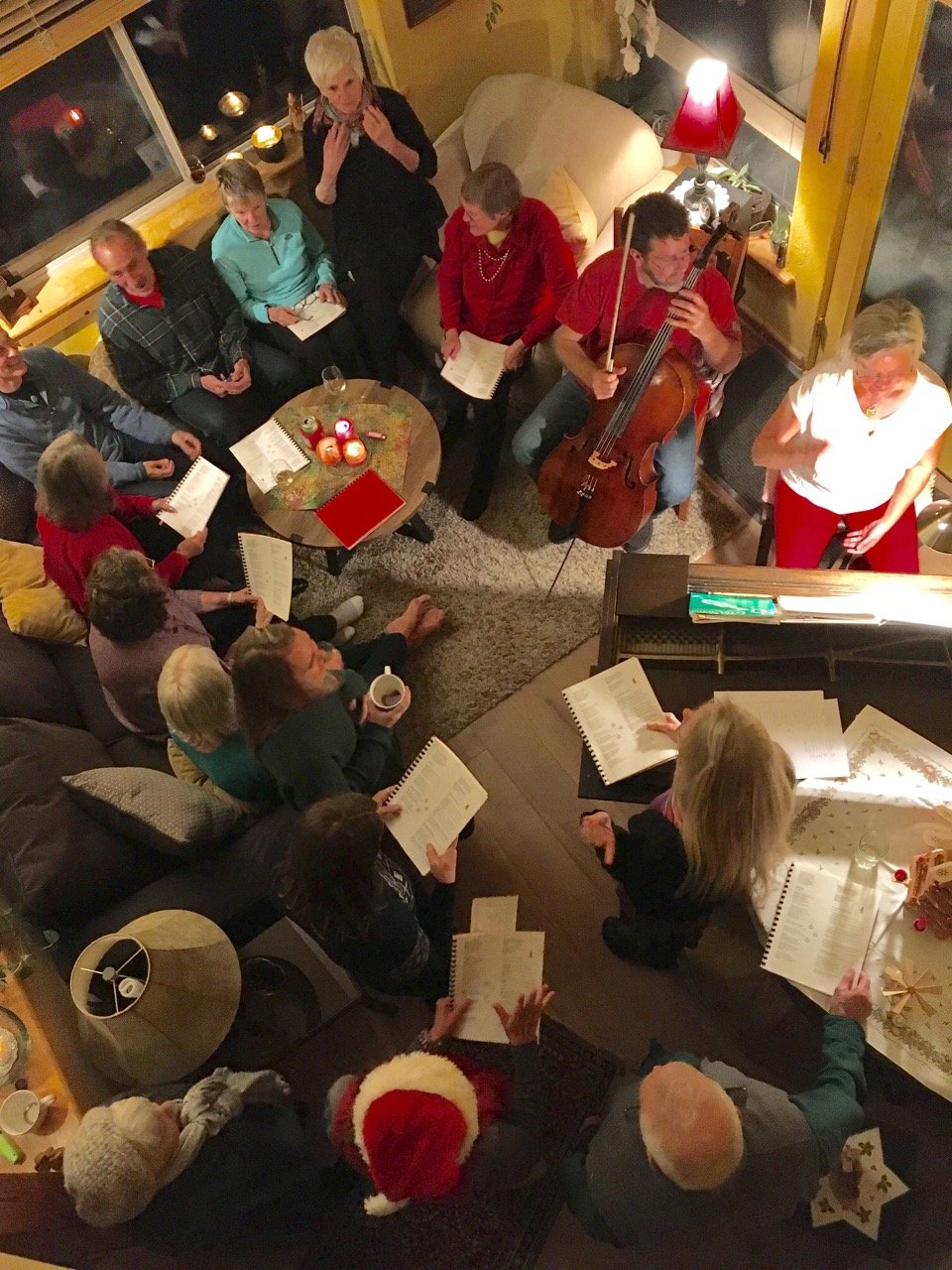 Holiday carolers gathered around the baby grand piano and cello in Nisargo and KJ's living room.