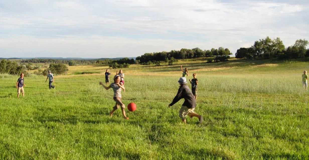 Playing soccer down in the pasture.