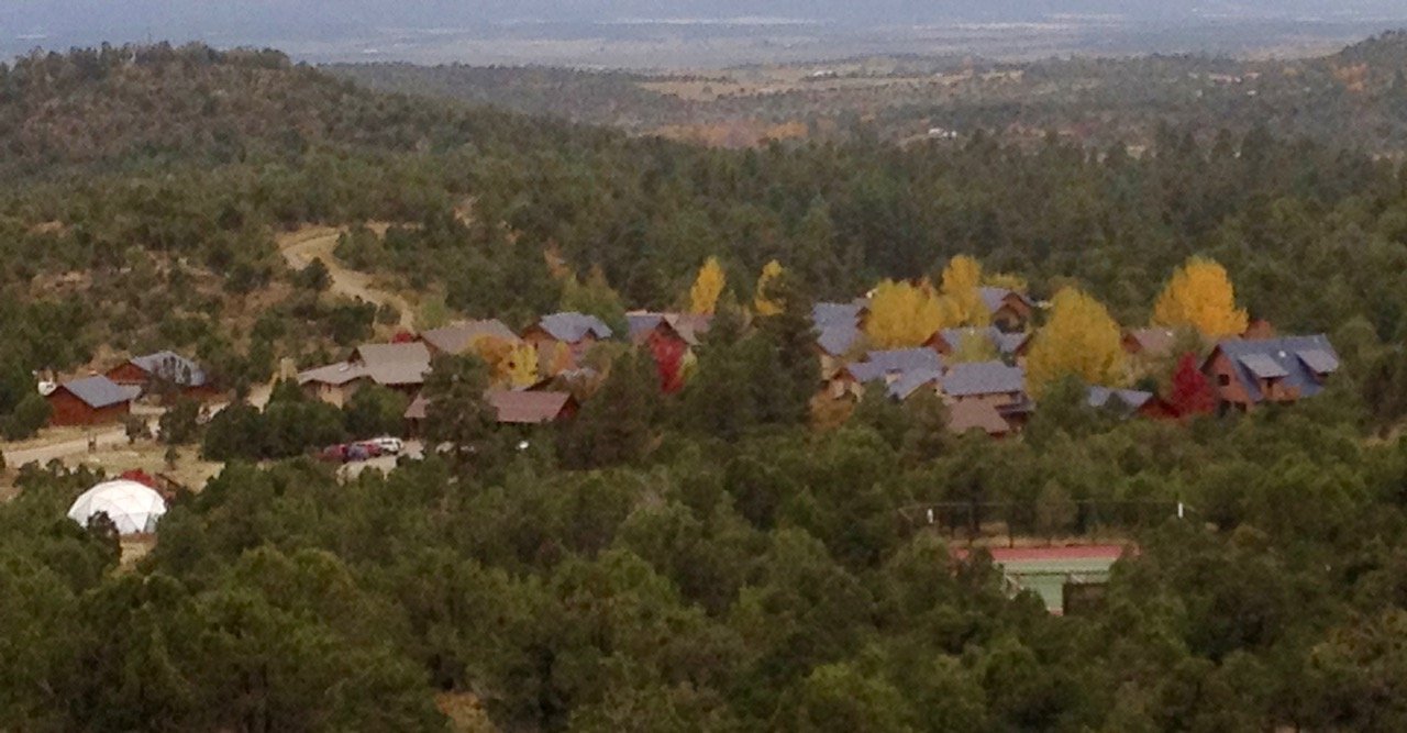 The cluster in autumn with the dome greenhouse and tennis and pickleball court in the foreground. Our new Phase 2 homes are being built between the court and the greenhouse on the left.

