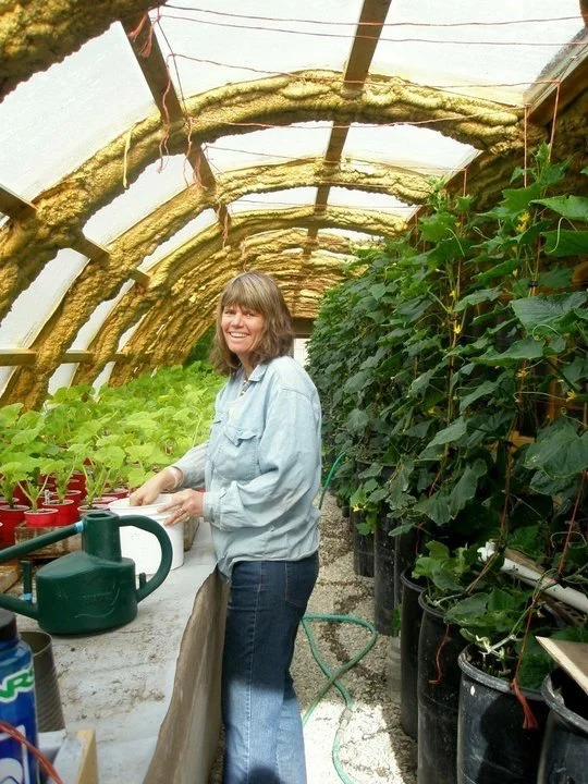 Sandy tending new starts in the seedling house.