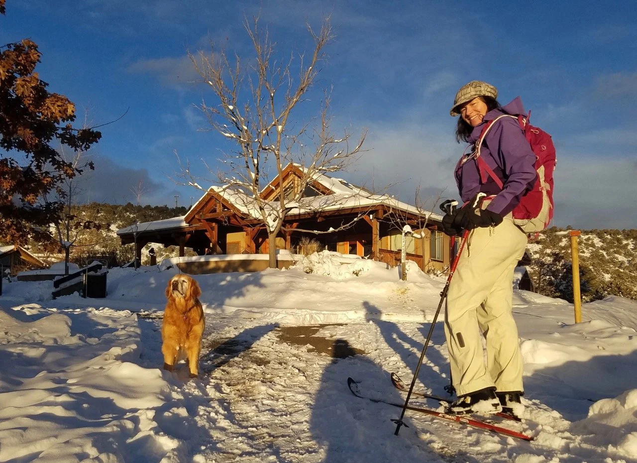 Katie cross country skiing past the common house.