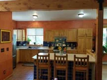 Kitchen with wooden cabinets, a window, and a dining table with chairs