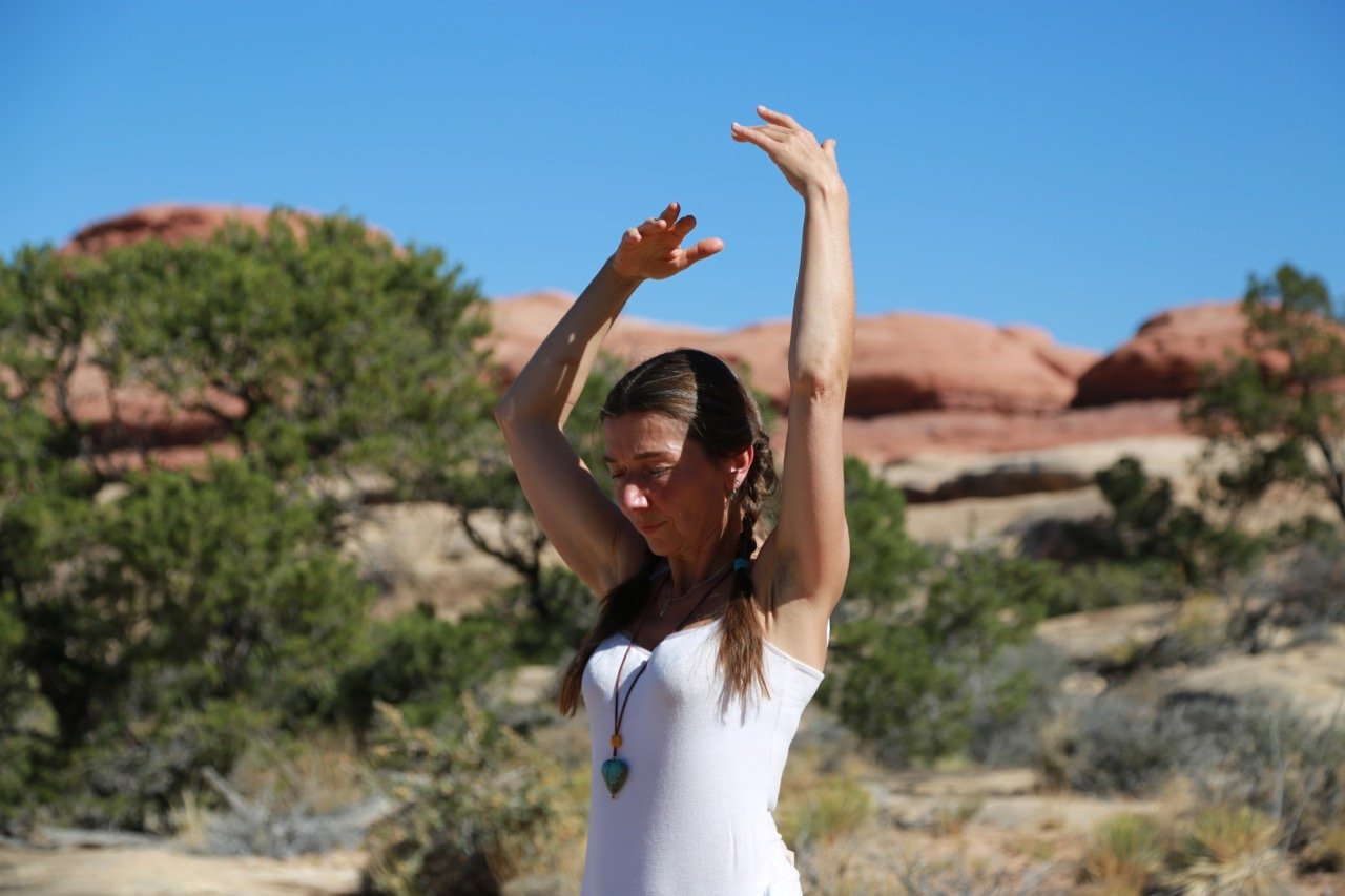 Isa practicing breath work in canyon country.