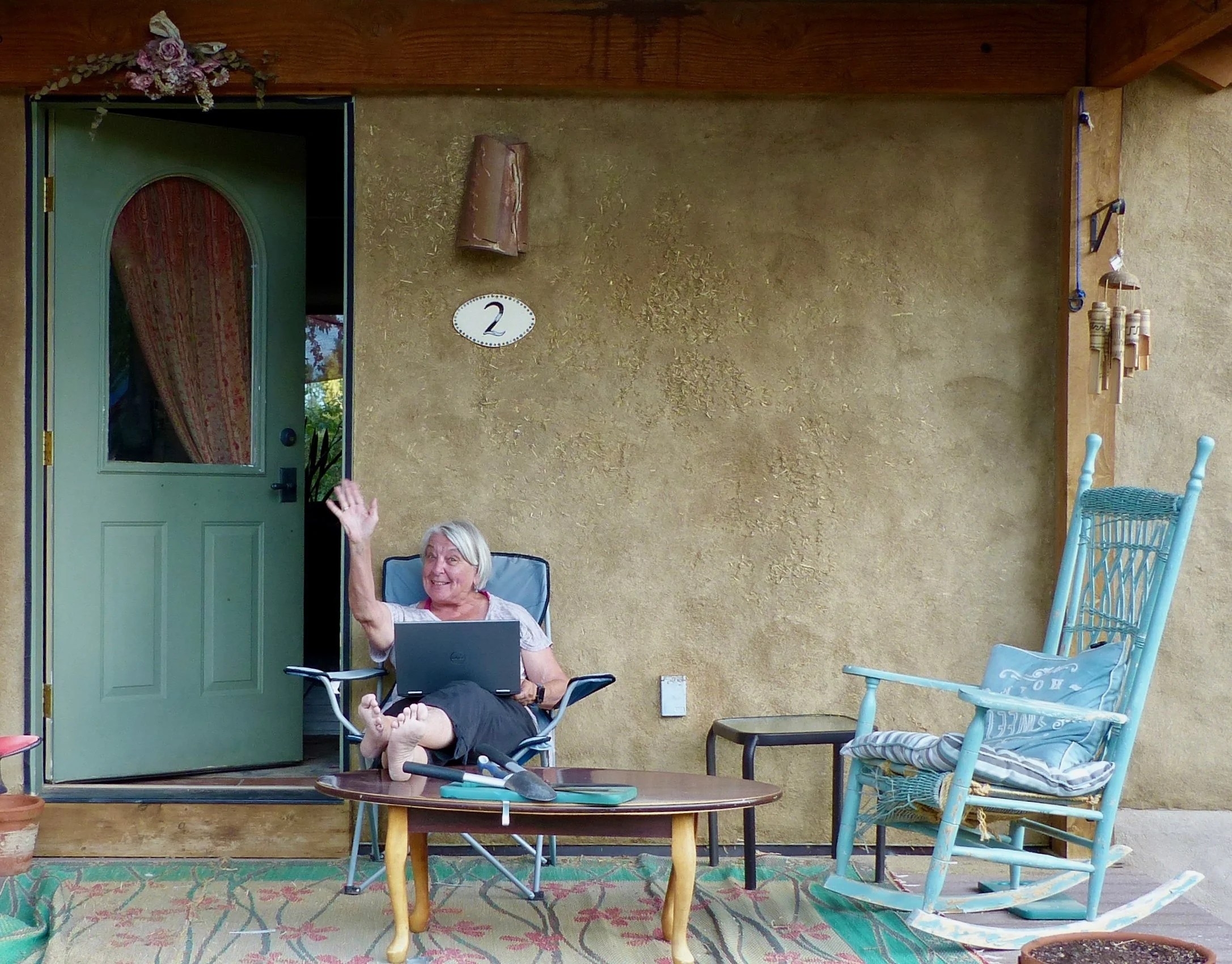 Julie working on her front porch, but open to friendly distraction.