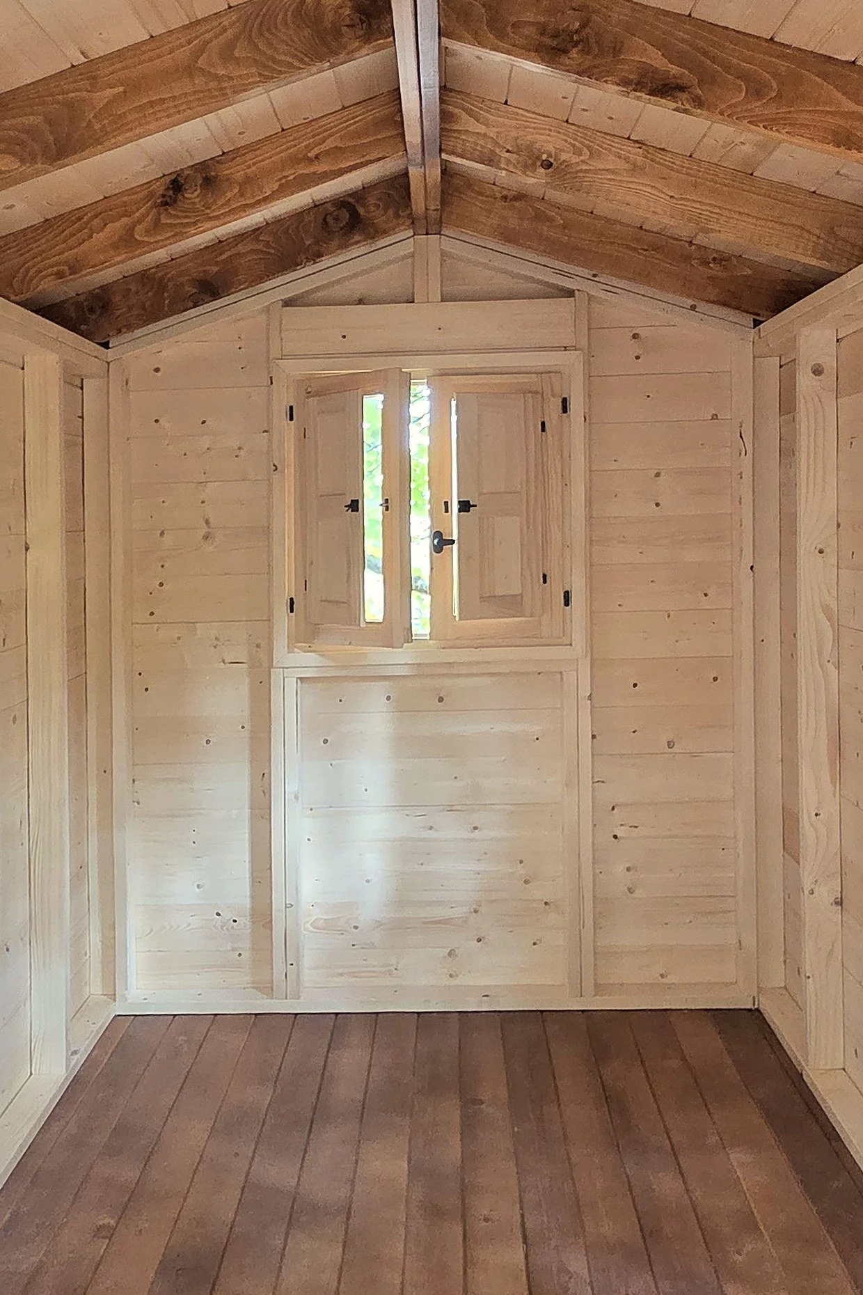 Interior de una casa en el árbol de madera con techo de vigas vistas