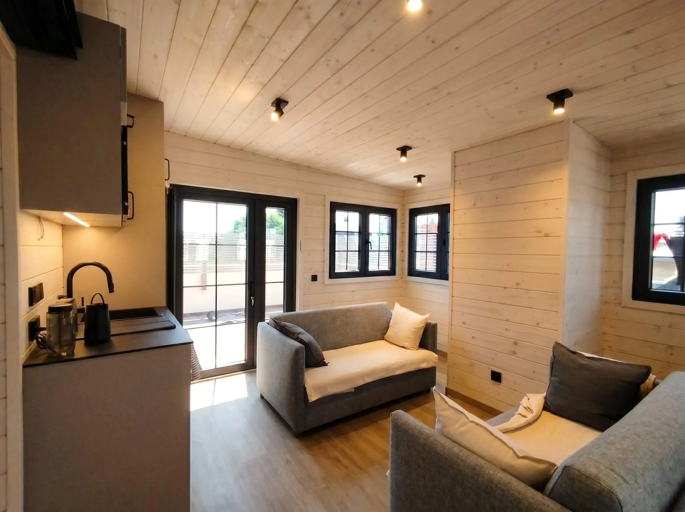 Interior de una ampliación de vivienda de madera con grandes ventanales
