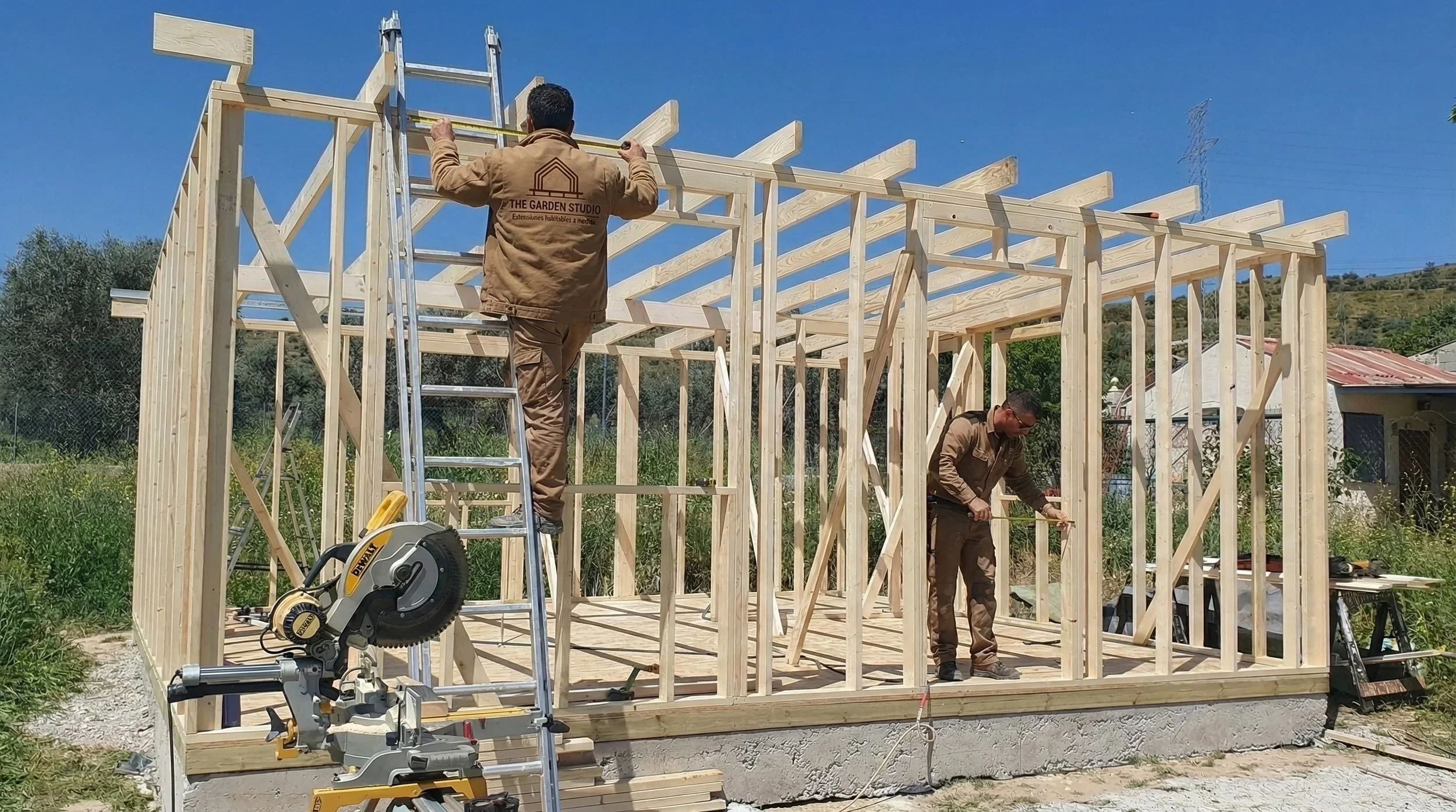 Dos constructores trabajando en la estructura de una casa de madera,  para habitación jardín — construcción sostenible en Madrid.