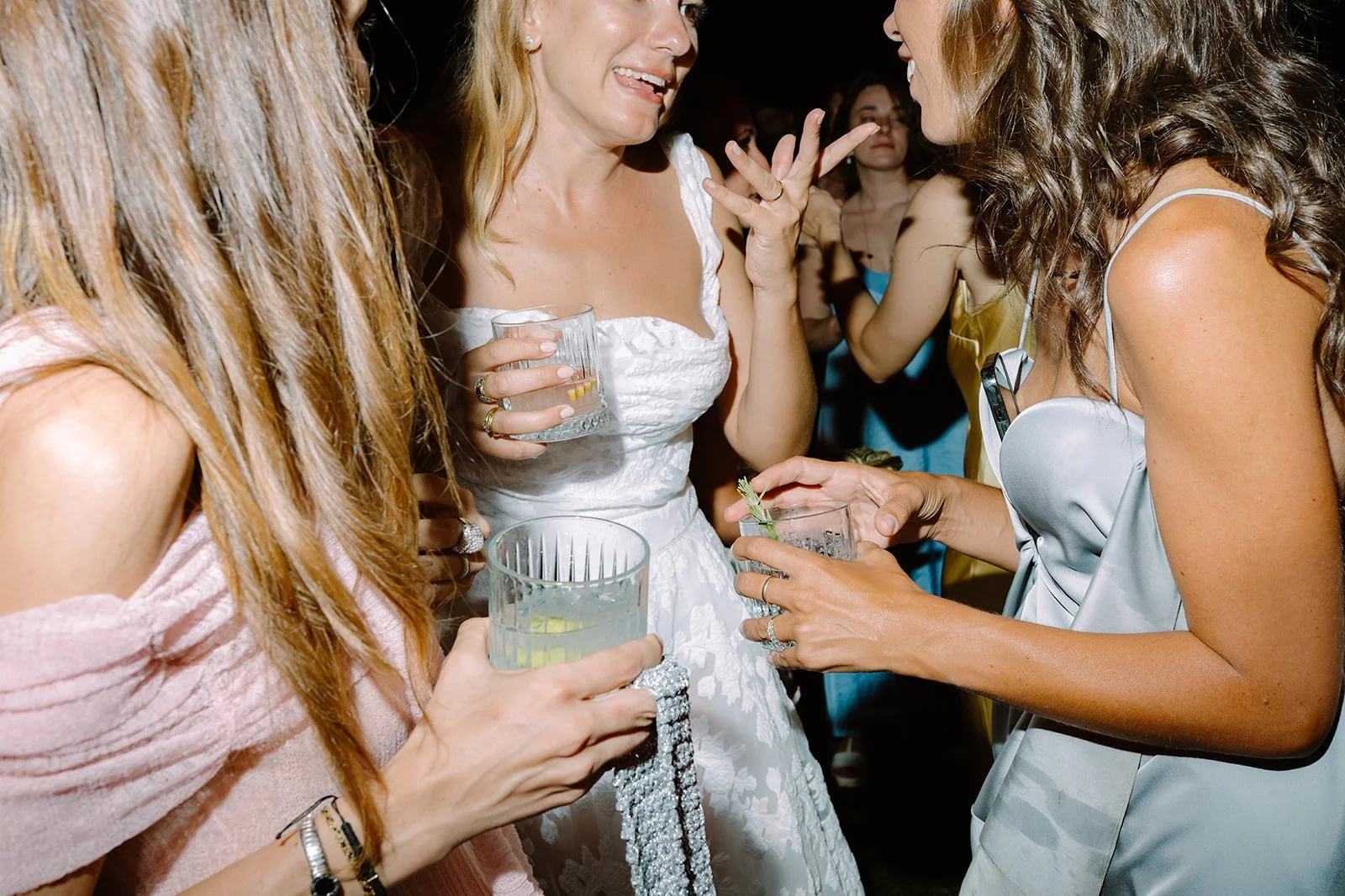 Women at a social gathering or party holding drinks and engaging in conversation.