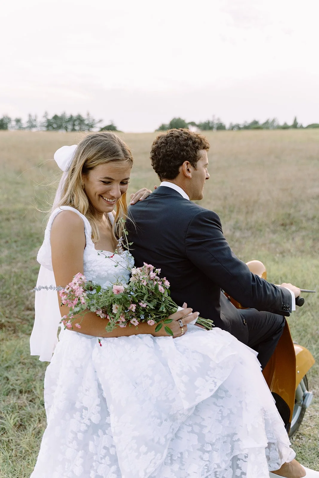 Wedding couple driving a vintage vespa in the Rome countryside