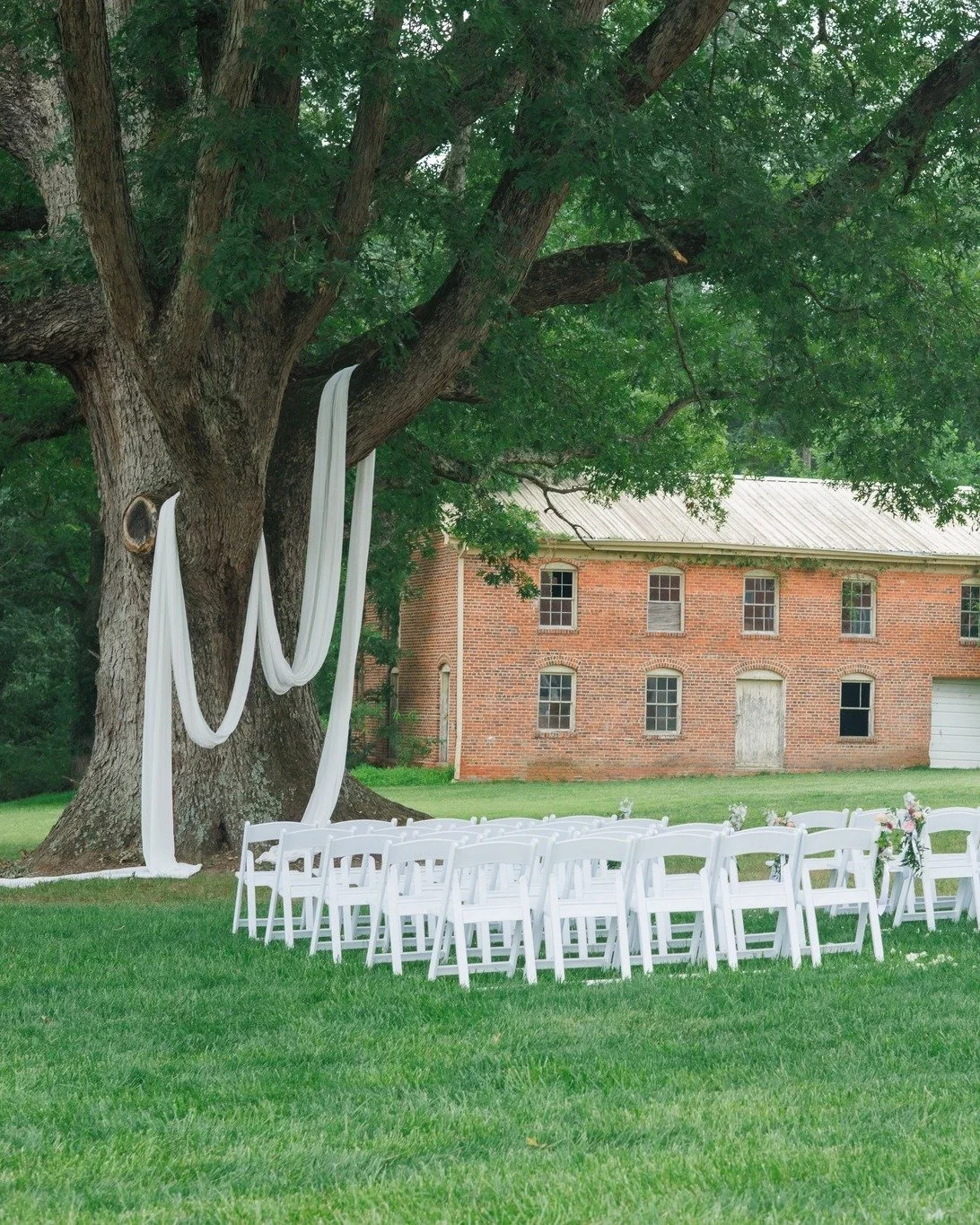 Shaded by history, framed in white. 🕊️✨ An outdoor ceremony under our grand oak tree brings together the best of both worlds: lush natural scenery and classic historic architecture right in the background. It&rsquo;s timeless, romantic, and effortle