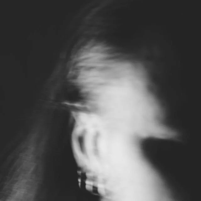 Black and white blurred image of a person's head and face in profile