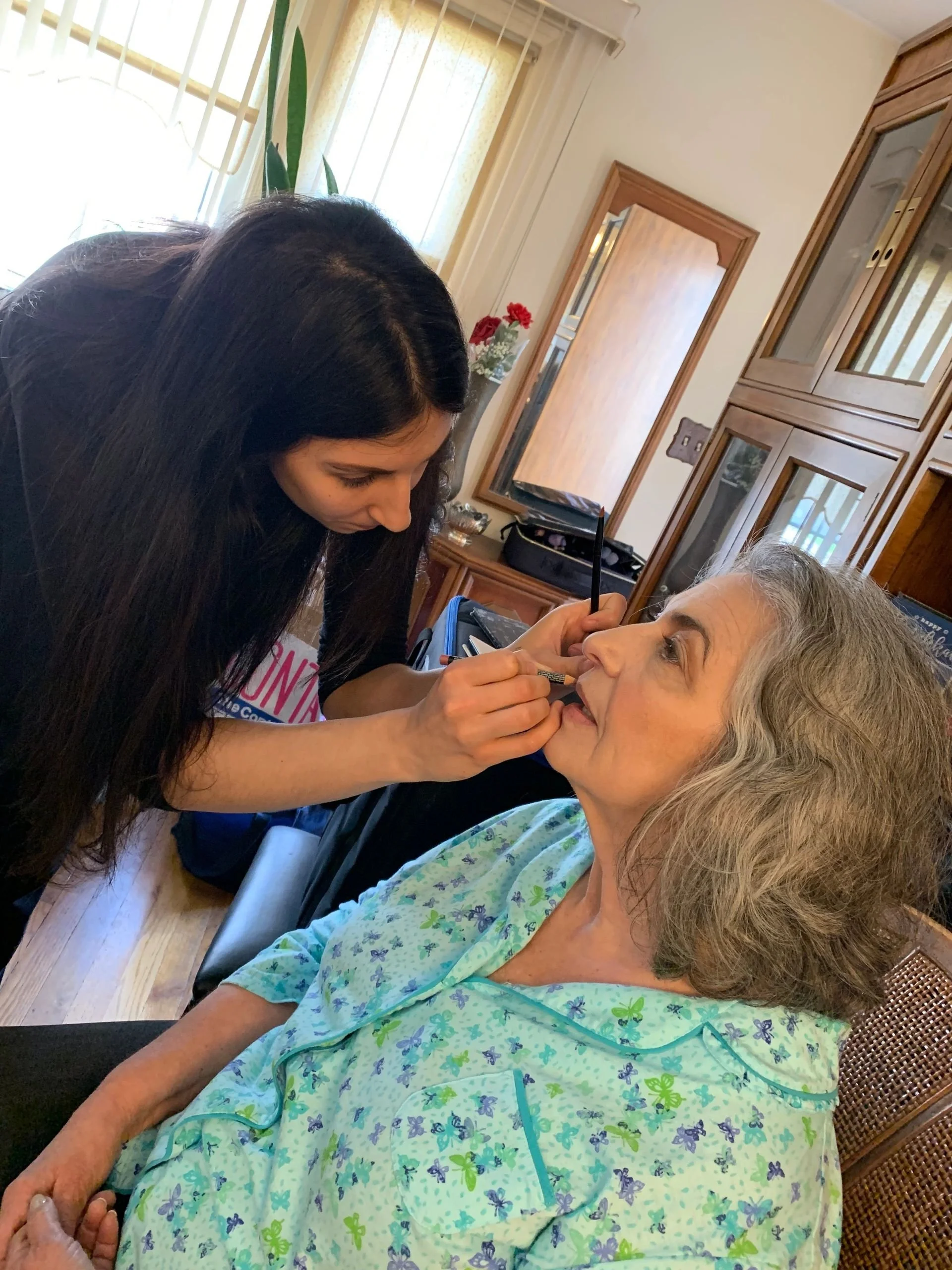 The makeup team applies their work for Elvira Tortora on set.