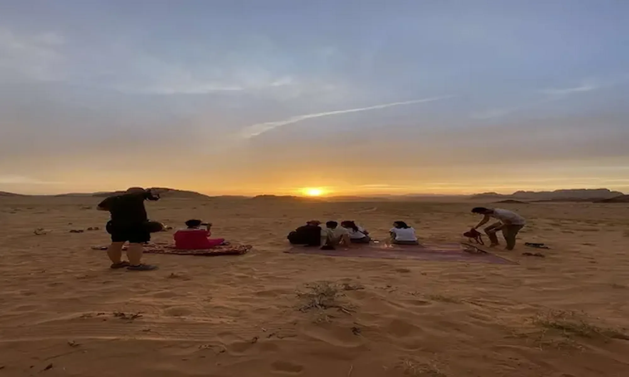 Guests relaxing in the desert at sunset during a Wadi Rum evening tour