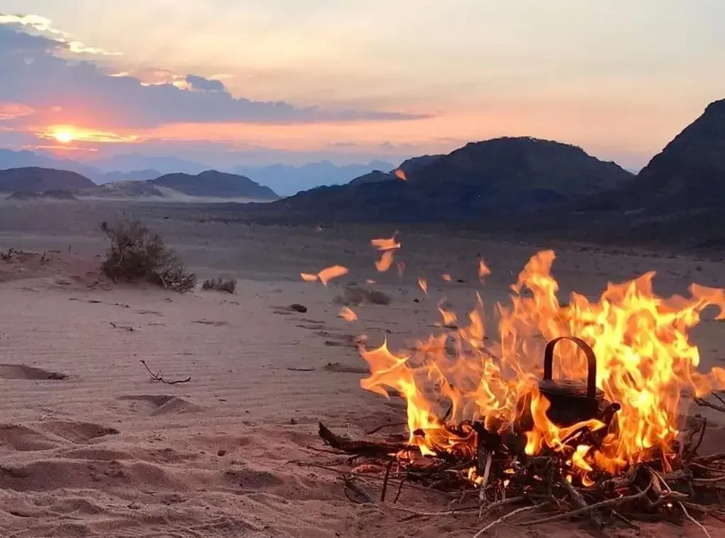 Wadi Rum desert sunset with mountains and campfire during evening in Jordan