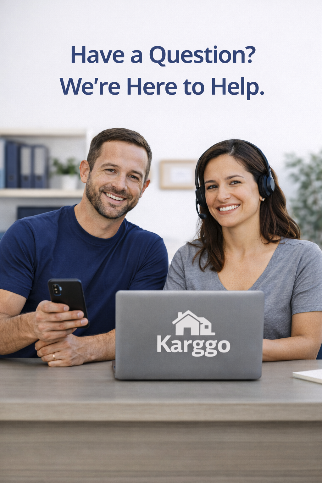 Smiling man and woman sitting at a desk with a laptop that has the 'Karggo' logo, woman wearing a headset, text saying 'Have a Question? We're Here to Help.'