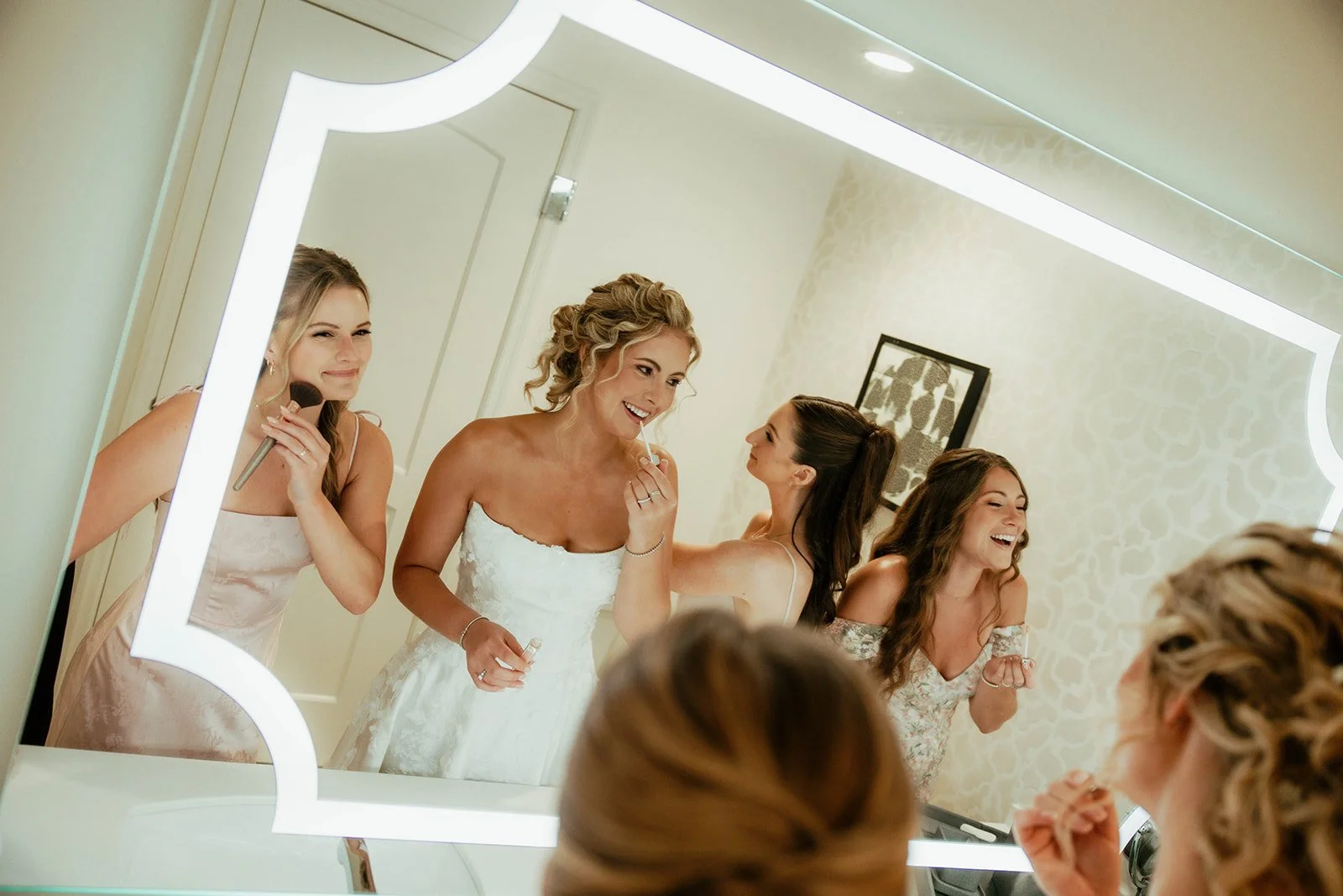 Bride and bridesmaids getting ready together in a bright bridal suite at Do’s & Dye Salon