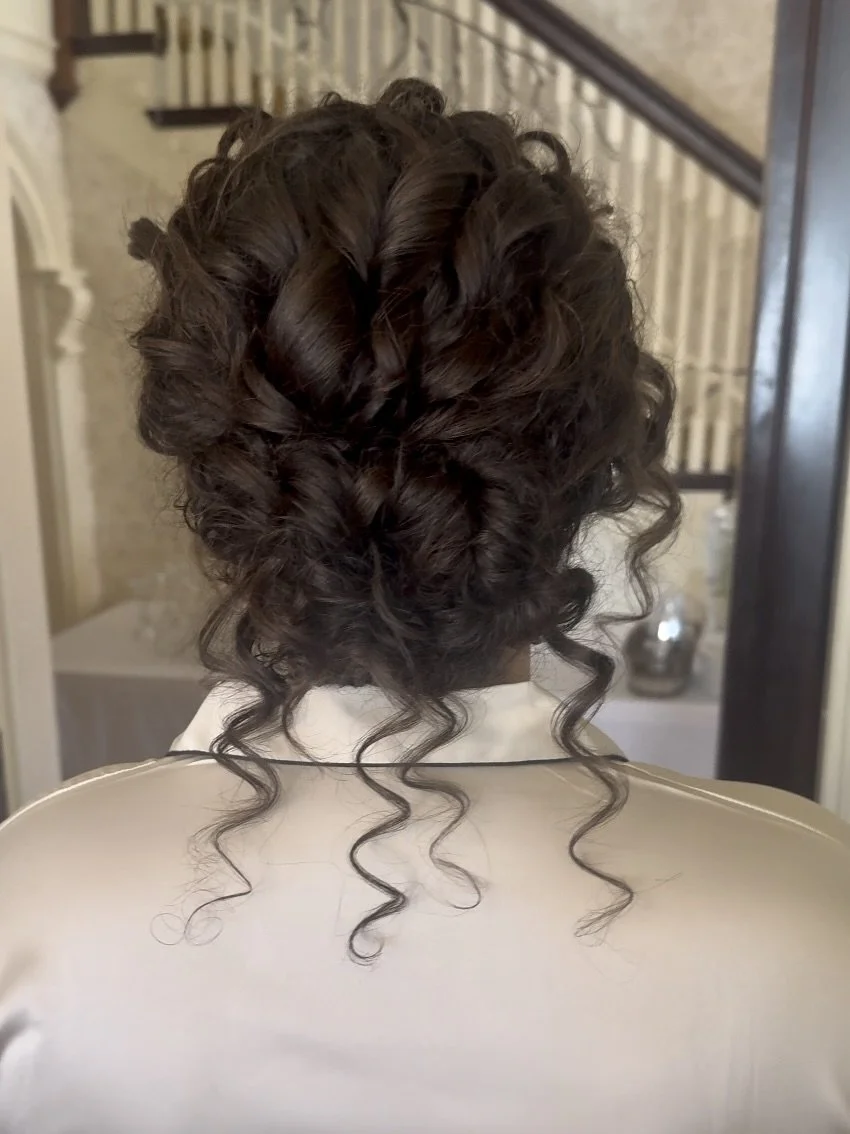 A dimensional updo with soft curl placement and a natural finish.