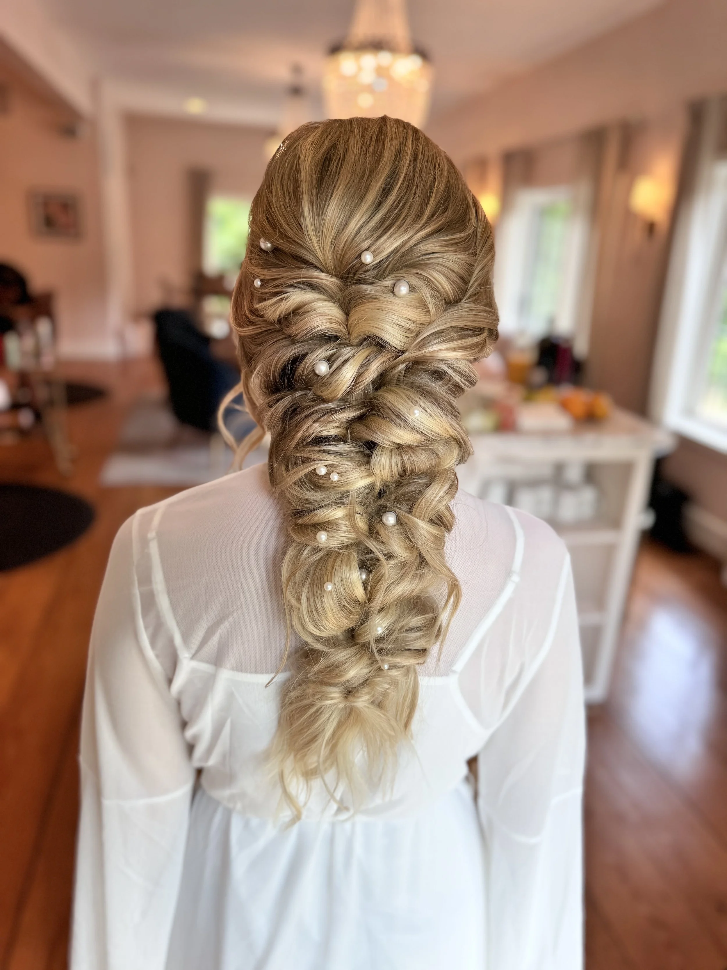 Intricate bridal braid with pearl details, wedding hairstyle by Do’s & Dye Salon