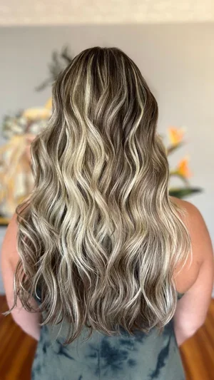 Long blonde hair with soft waves and lived-in color at Do’s & Dye Salon