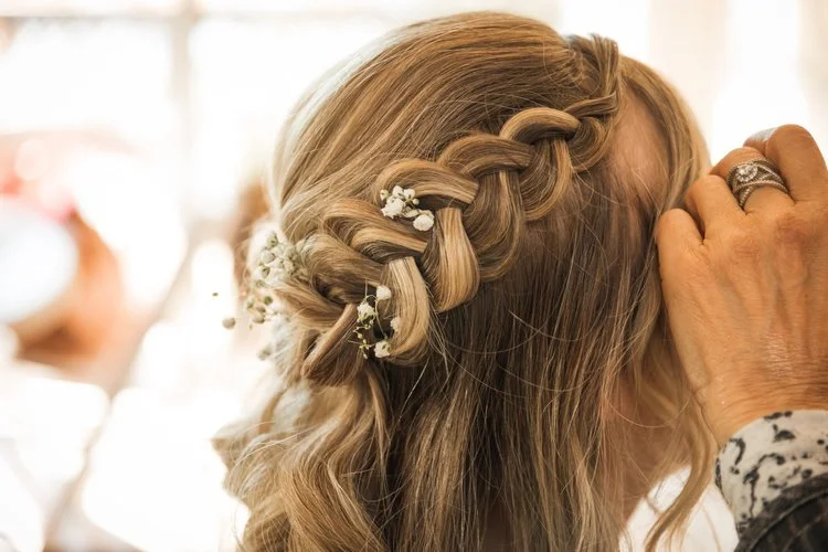 Bridal braid hairstyle with delicate floral details, wedding hair styling by Do’s & Dye in West Hartford