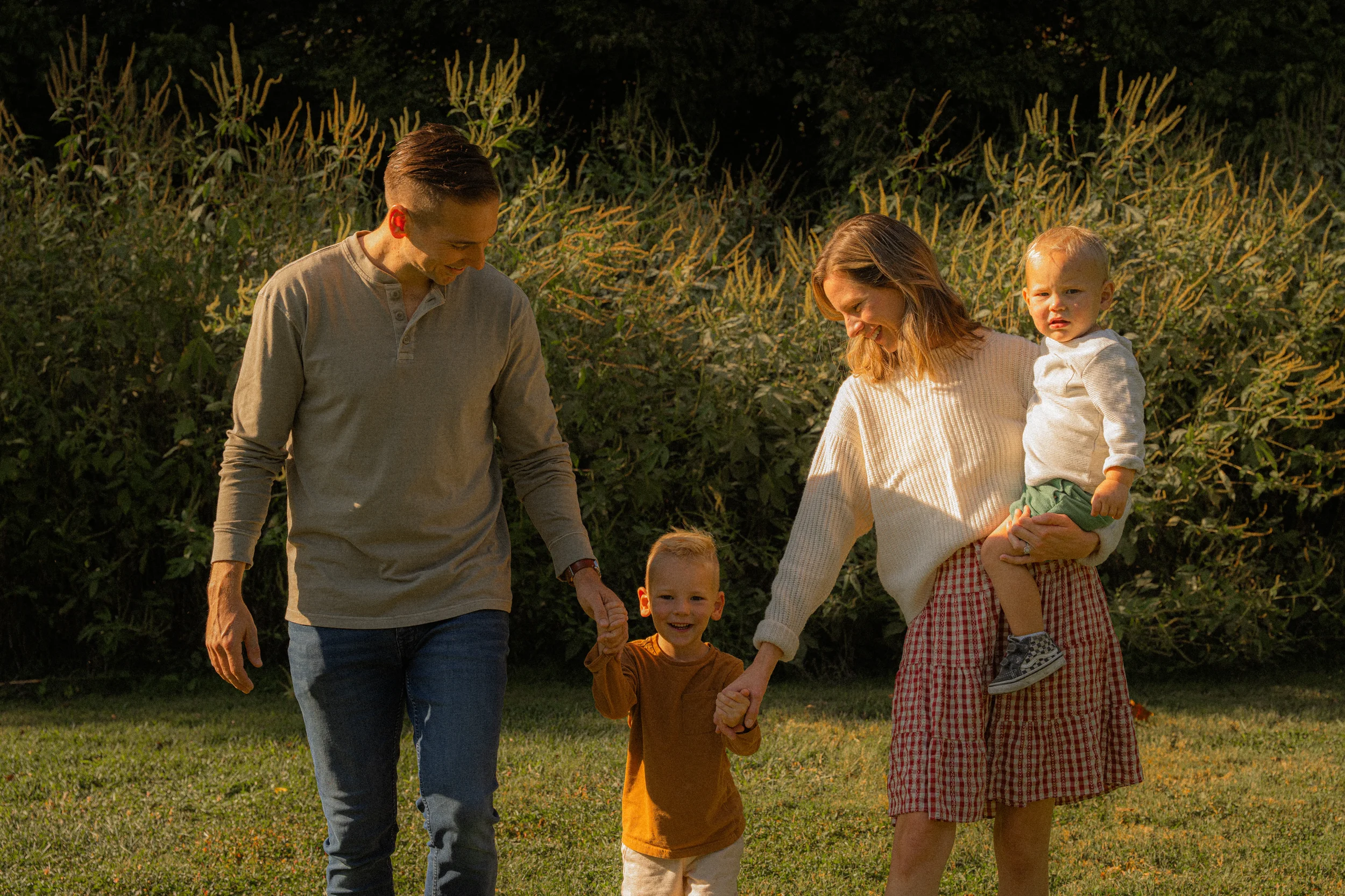 Parents admiring child walking through field