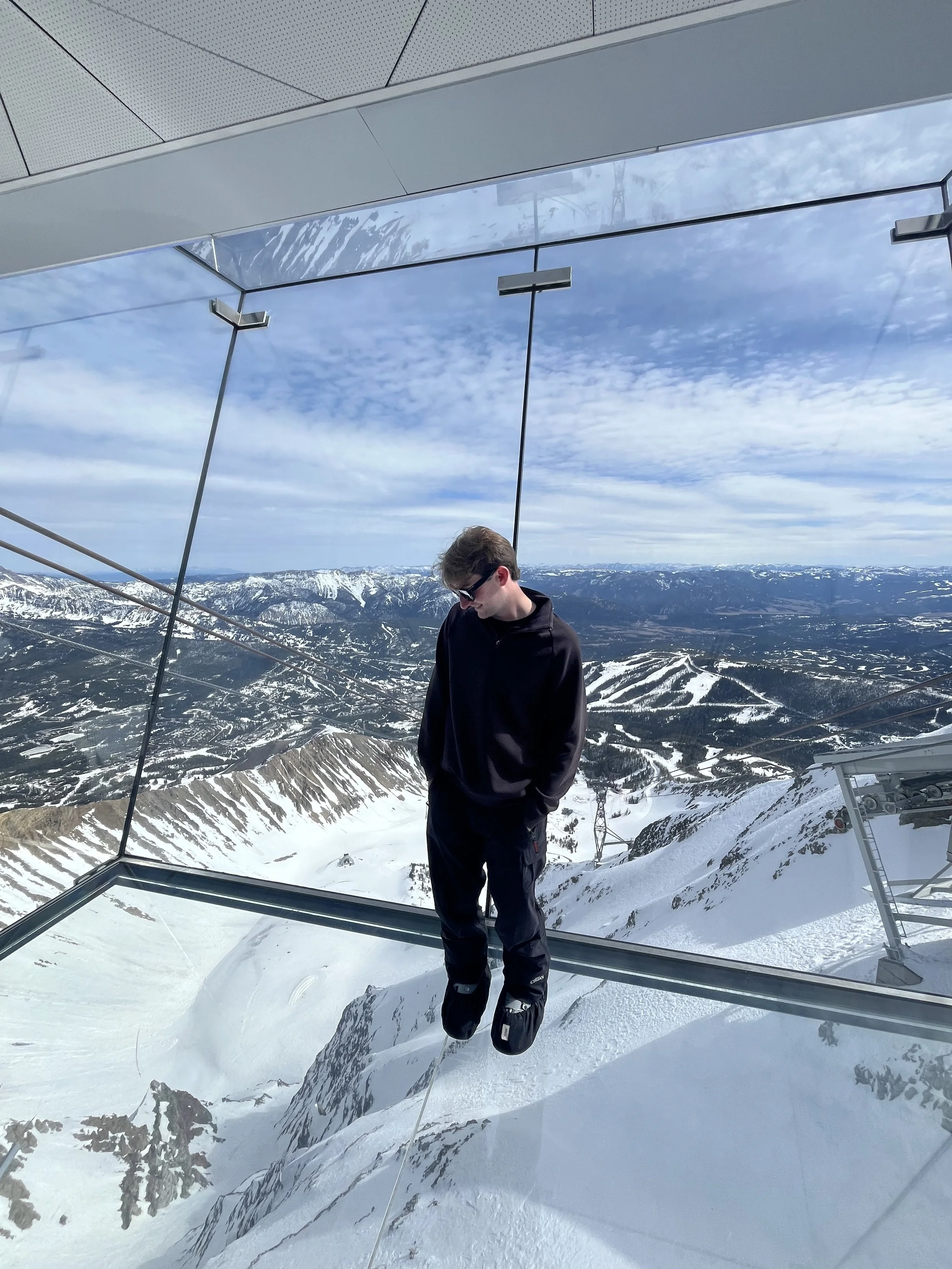 Me standing in a glass overlook atop the largest mountain peak.