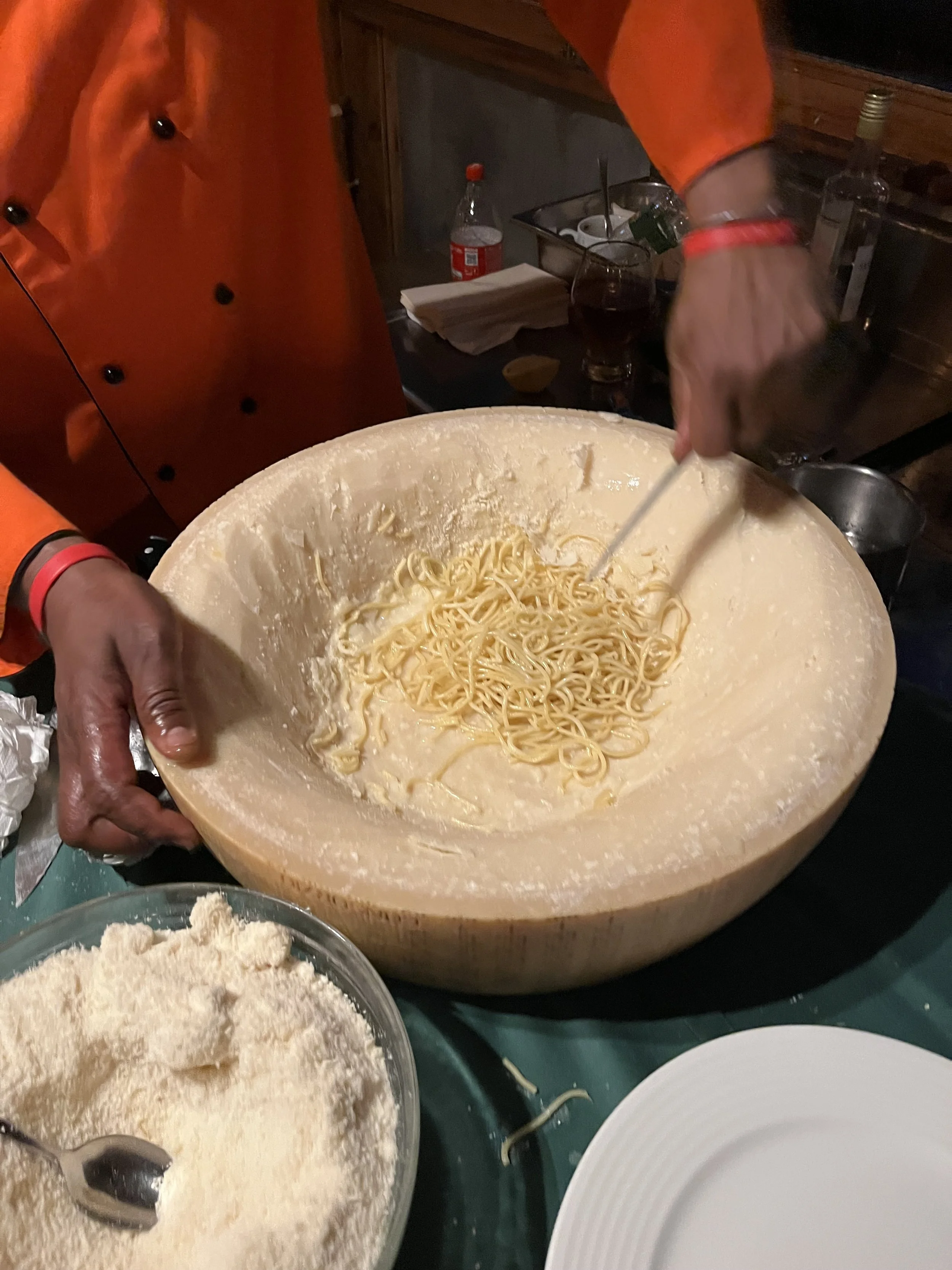 Pasta being prepared in a cheese wheel.
