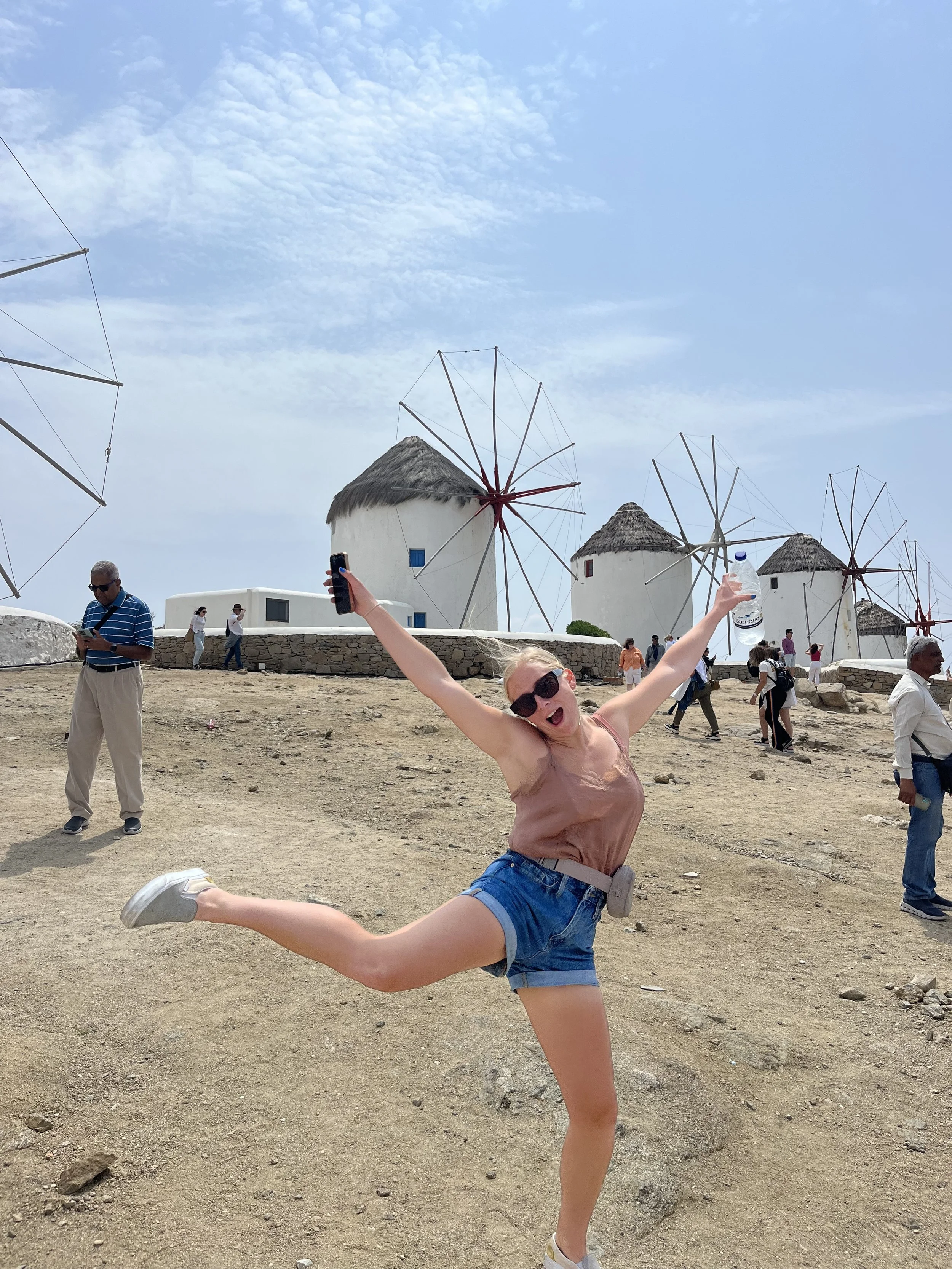 Joseph's sister posing in front of the iconic Mykonos windmills.