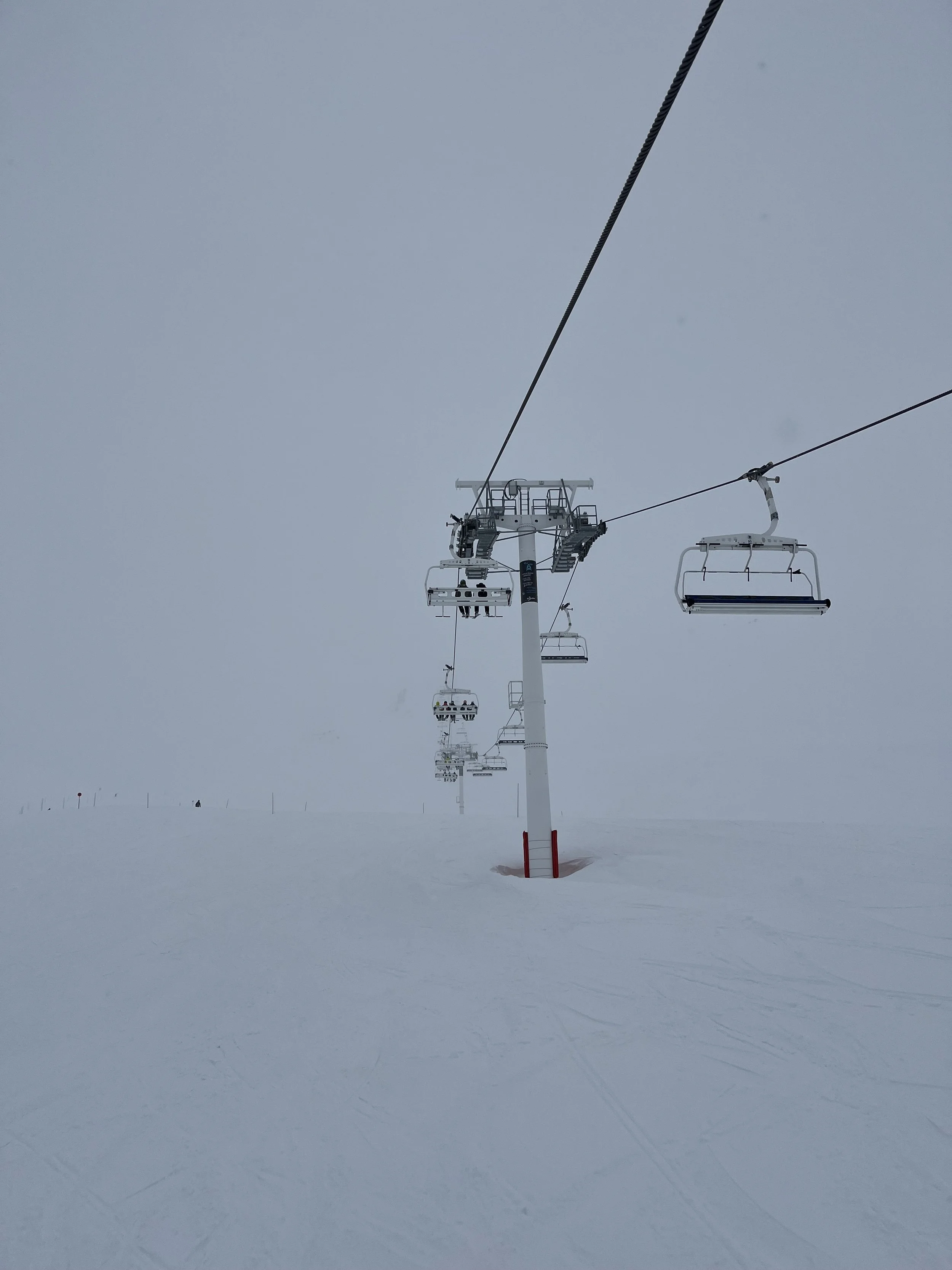 Chair lift in a white-out.