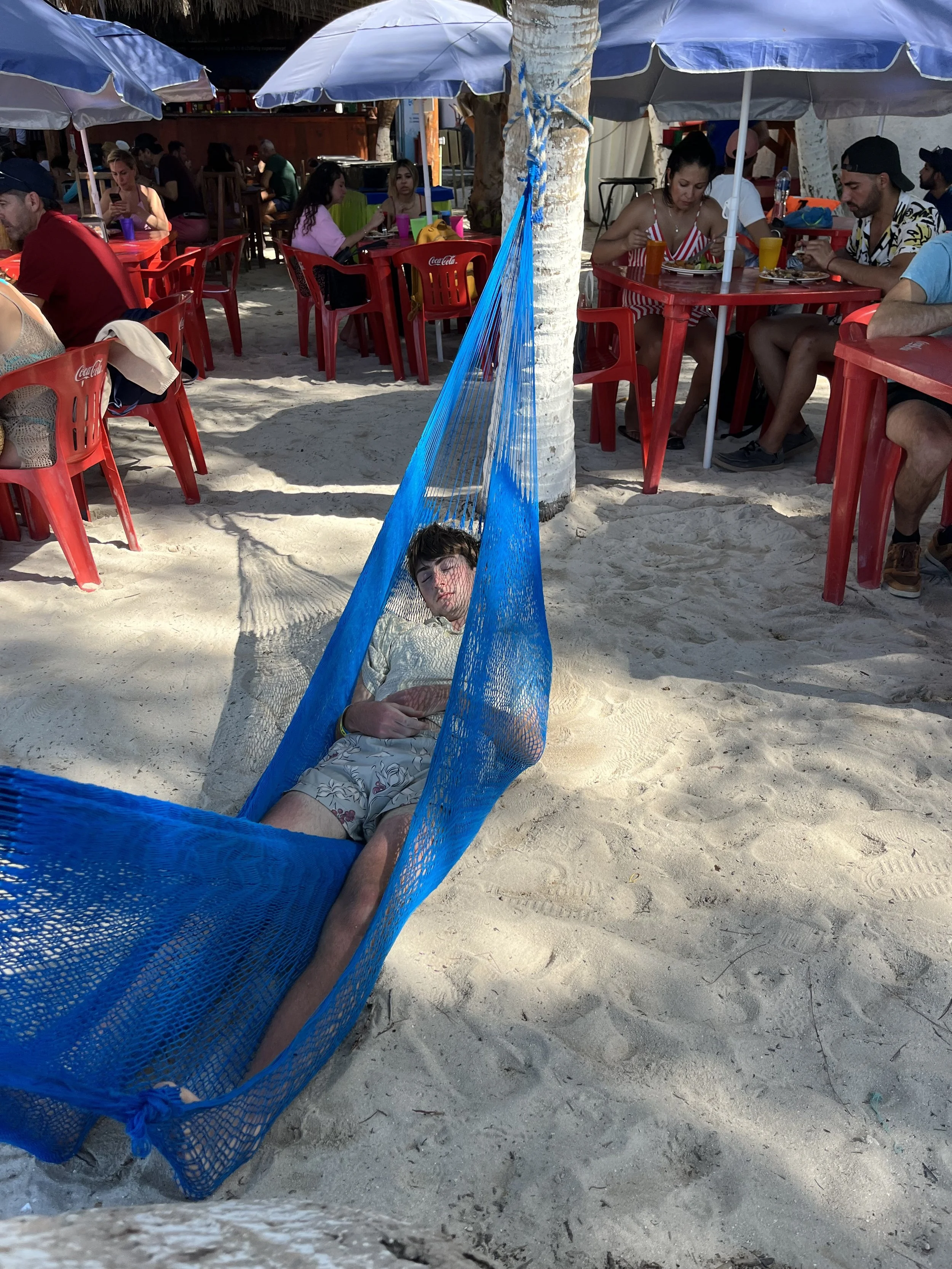Joseph taking a nap on the beach in a hammock.