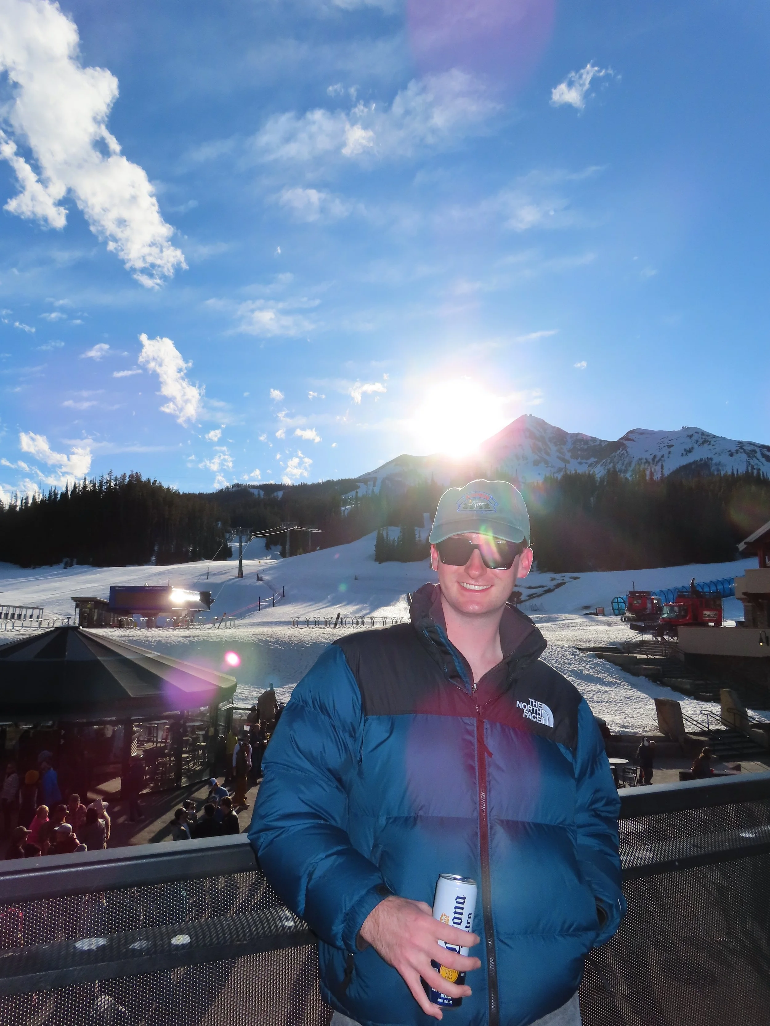 Myself posing in front of the sun setting behind mountains.