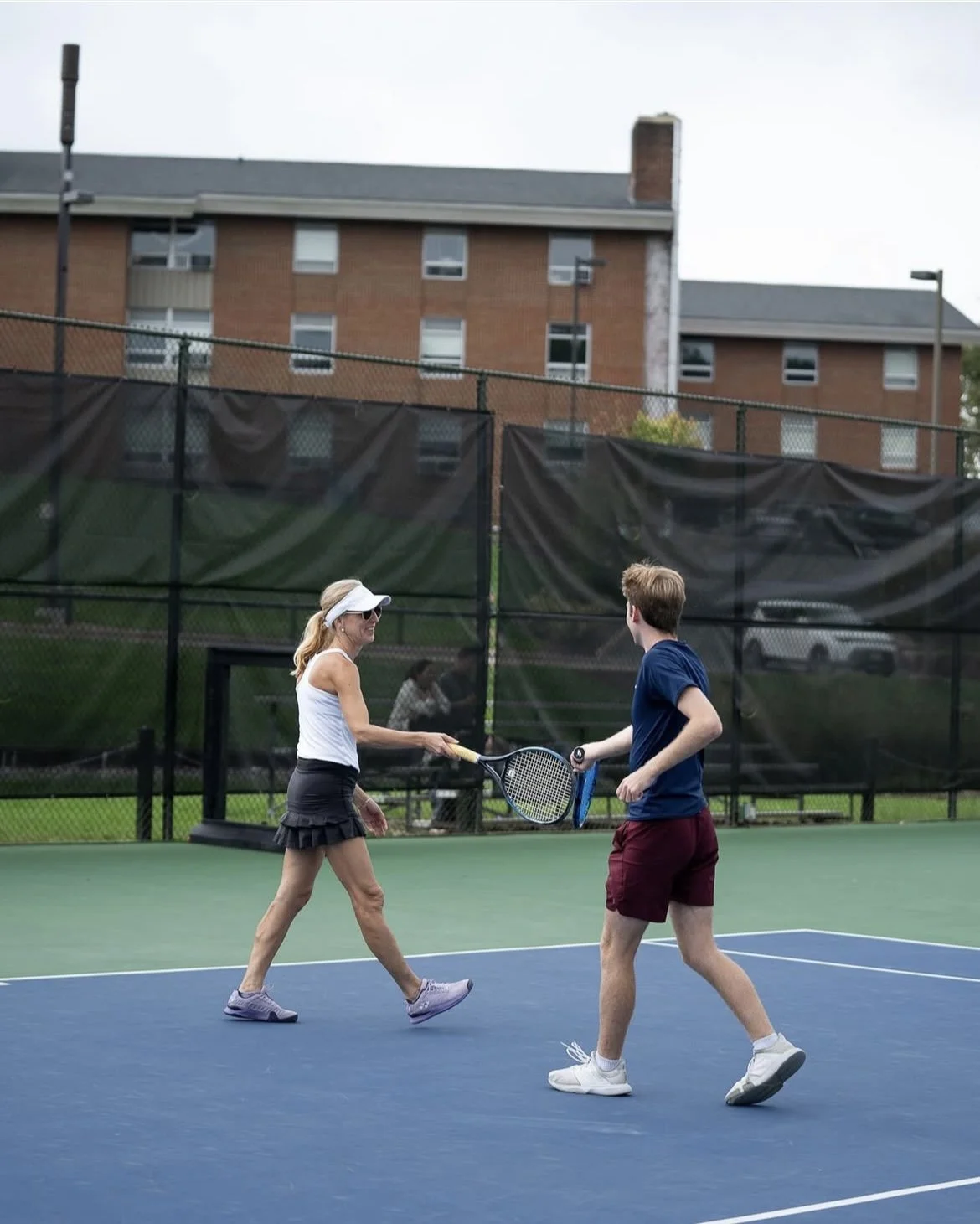 Joseph tapping racquets with his doubles partner during a family tournament