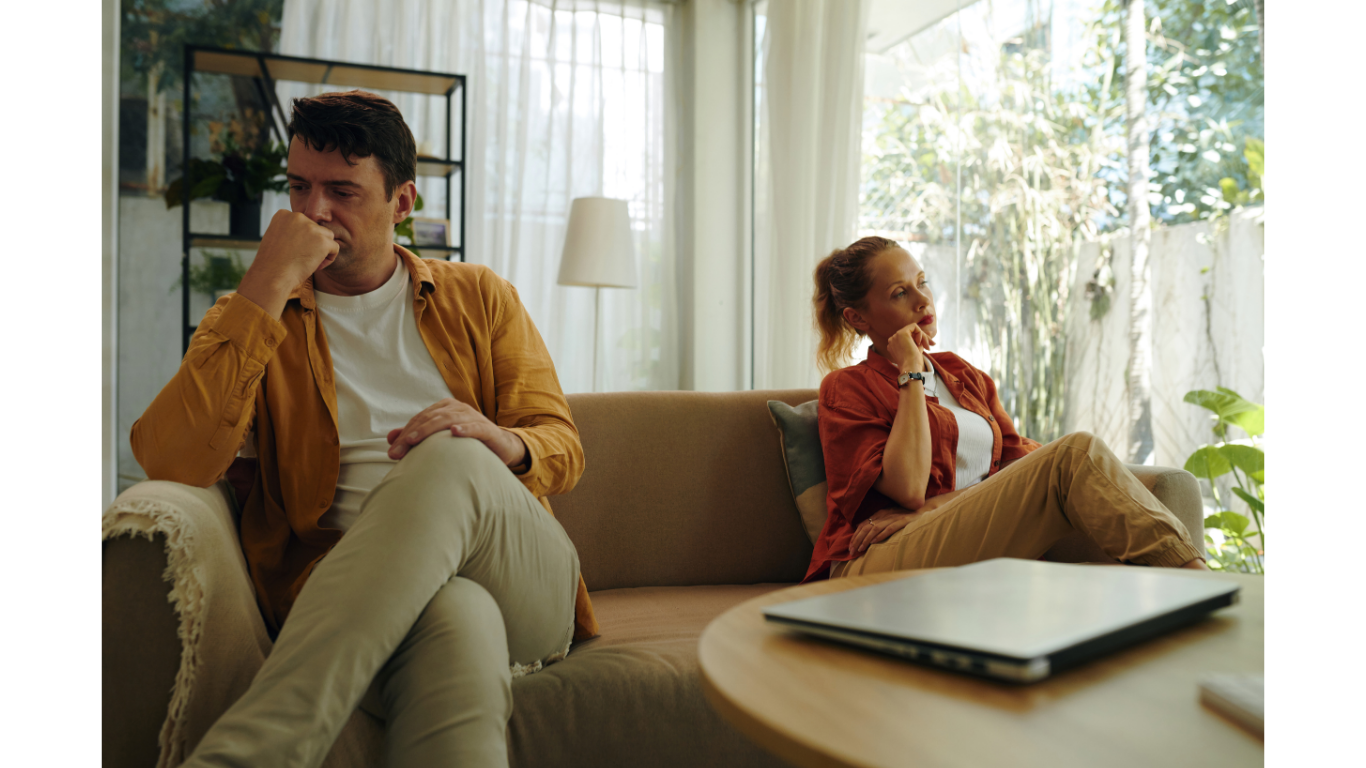 couple on couch looking away from each other and upset