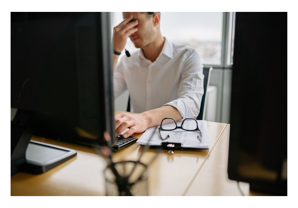 Stressed out husband at computer with hands on face