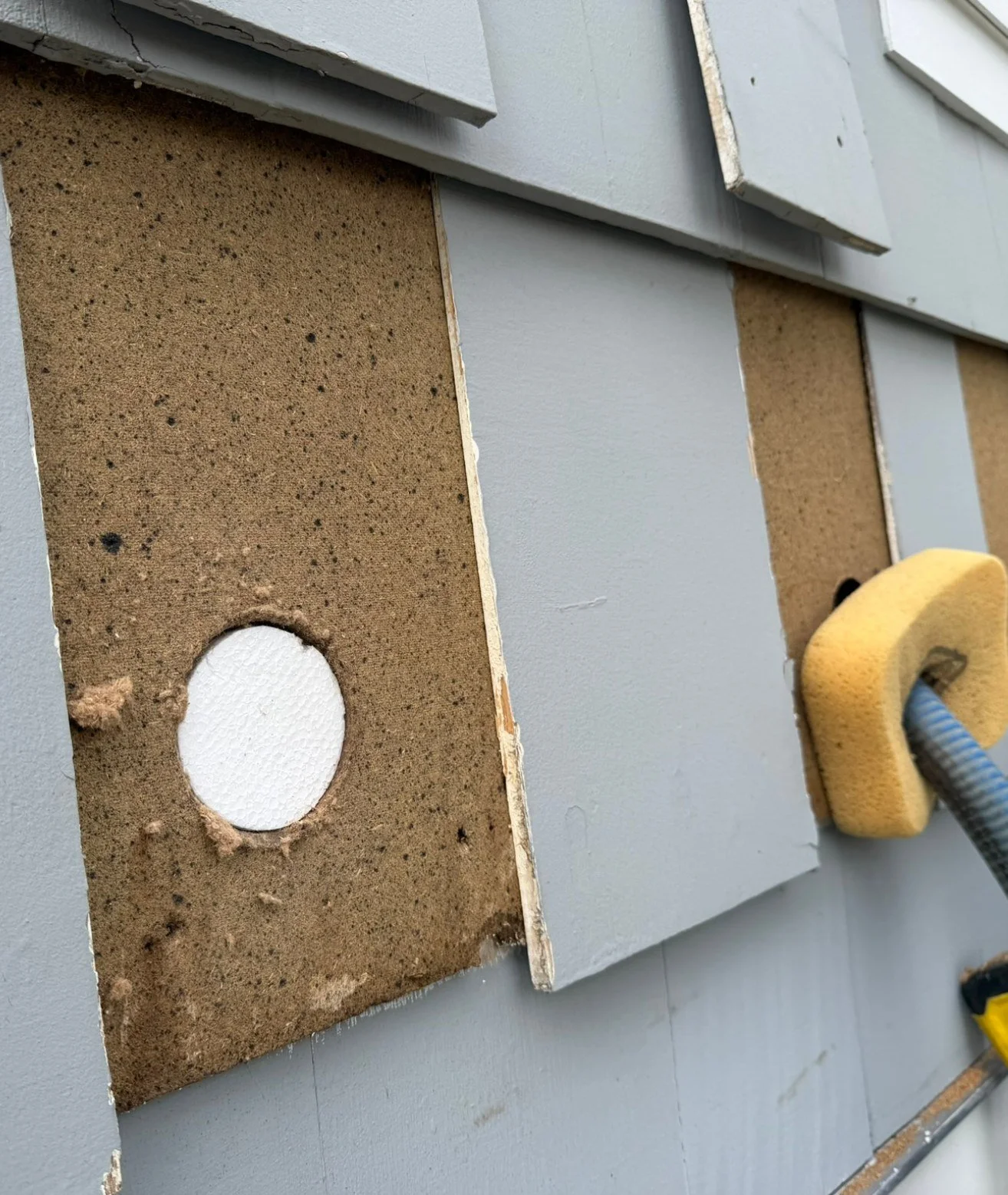 Dense-pack wall insulation being blown into an exterior wall by No BS Home Services LLC in Connecticut.